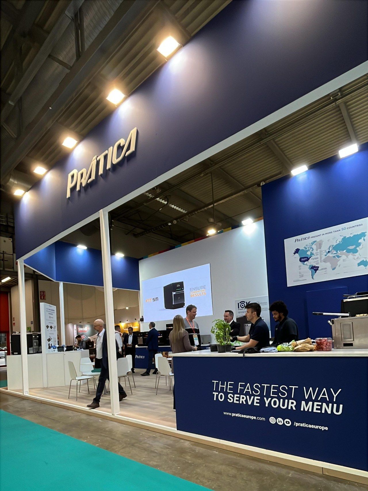 Estande da Pratica em uma feira comercial, cores azul e branco, pessoas olhando, slogan: 