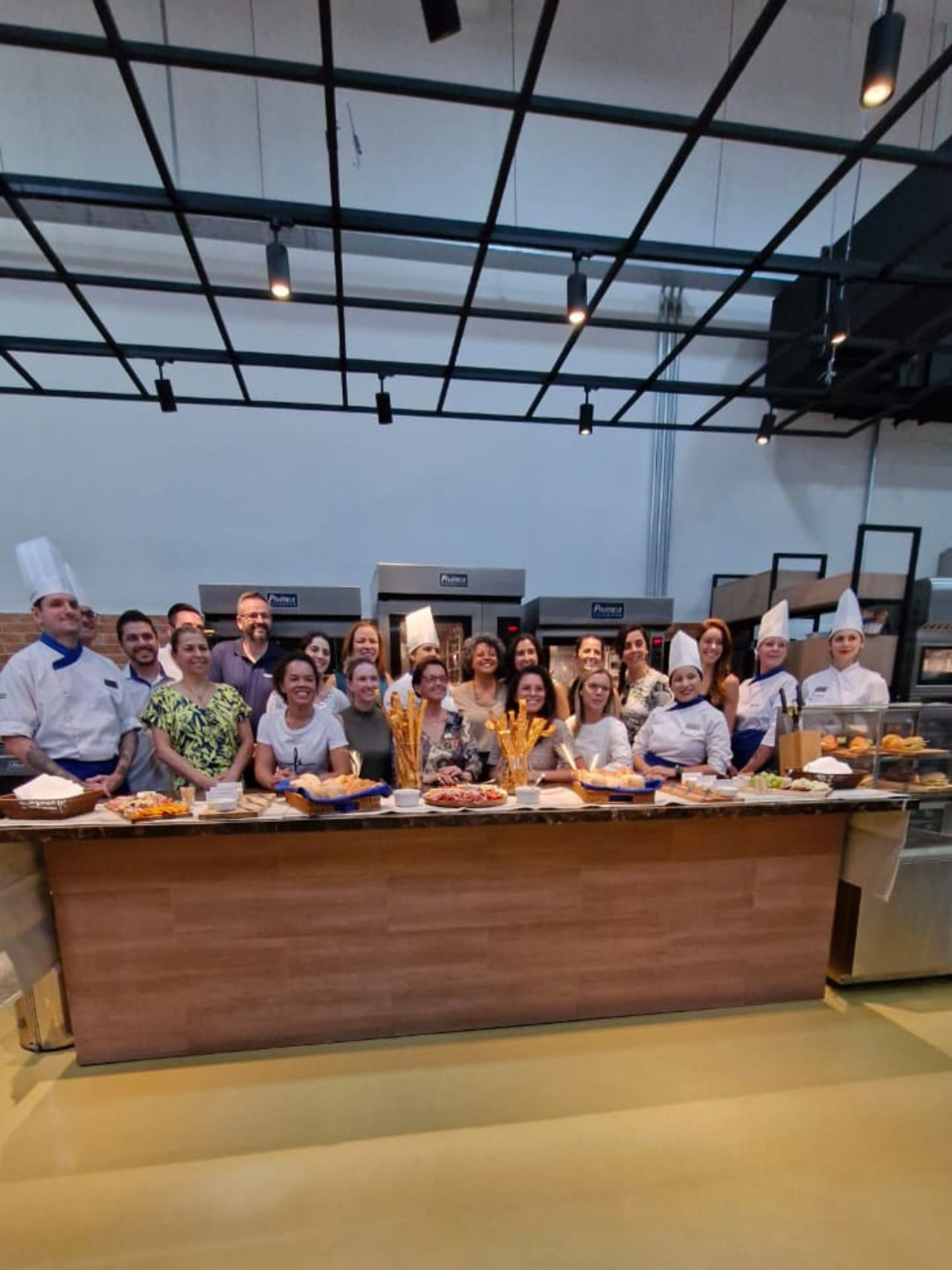 Um grupo de pessoas está posando para uma foto em uma cozinha.