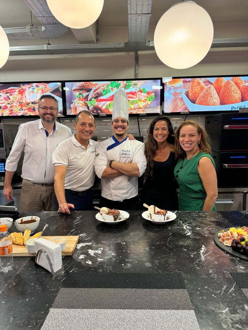 Um grupo de pessoas está posando para uma foto em uma cozinha.
