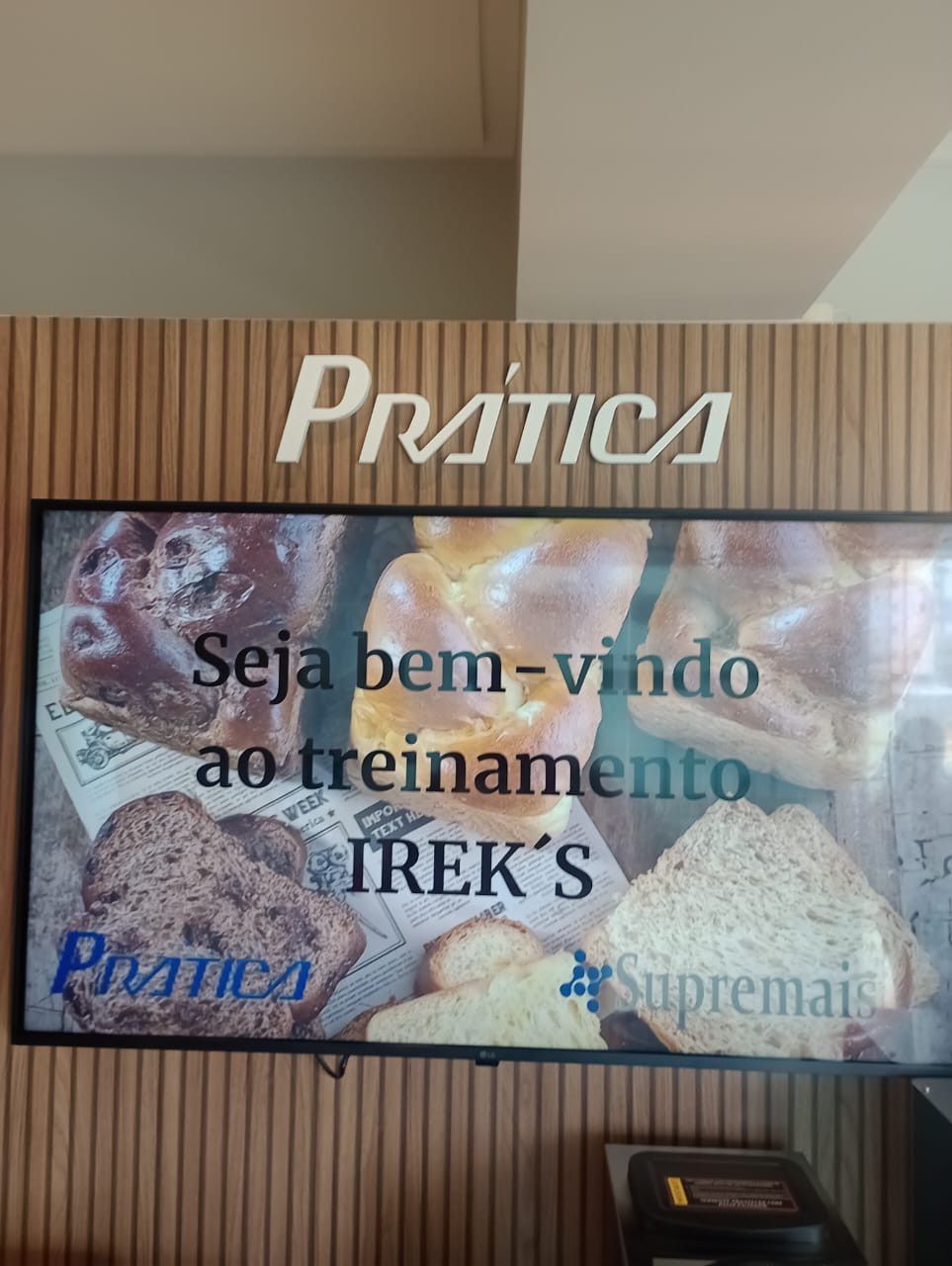 A tv is hanging on a wall with a sign that says