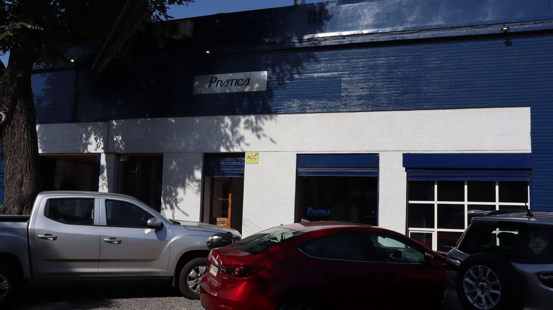 Um carro vermelho está estacionado em frente a um prédio.