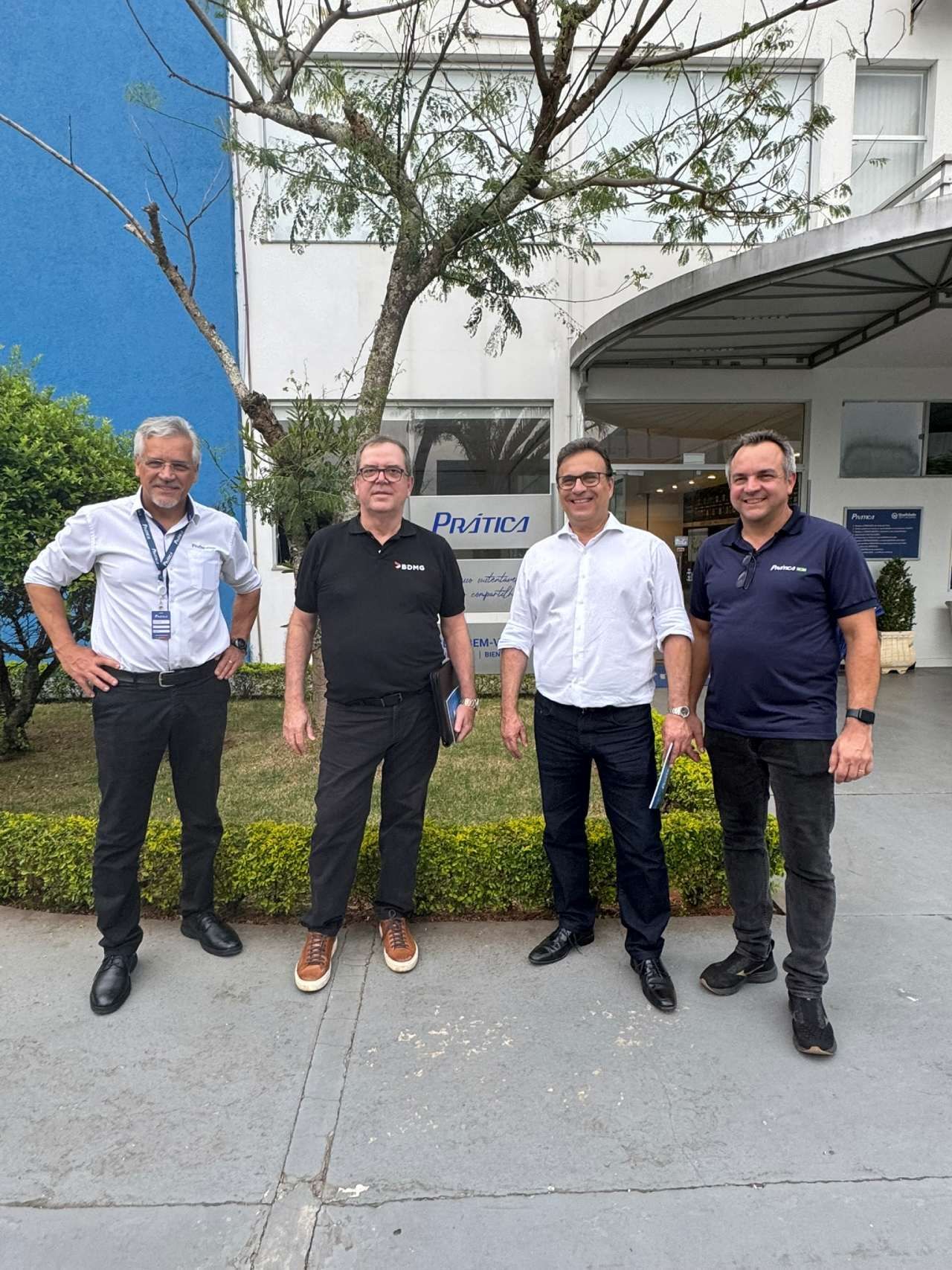 Um grupo de homens está parado em frente a um prédio.