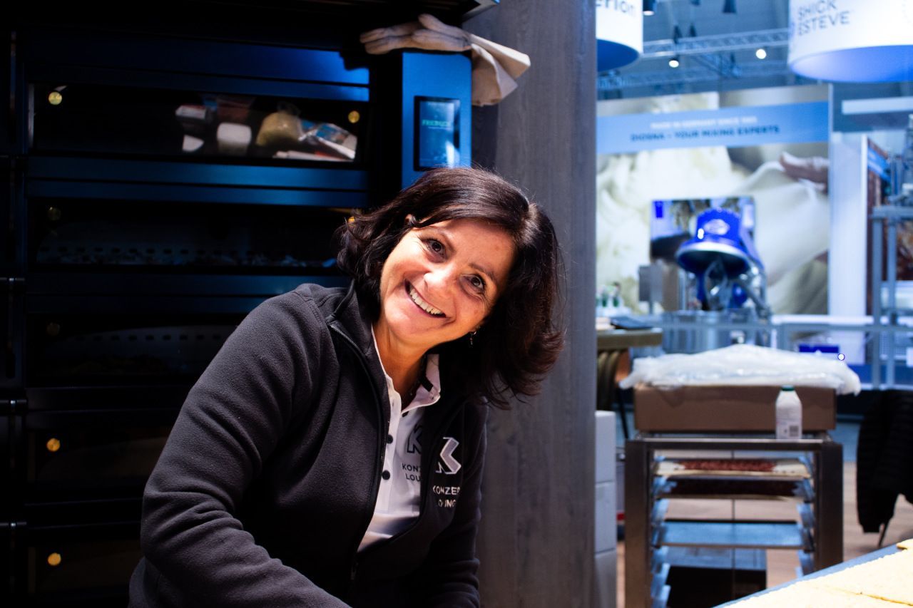 Uma mulher vestindo uma jaqueta preta com a letra s nela