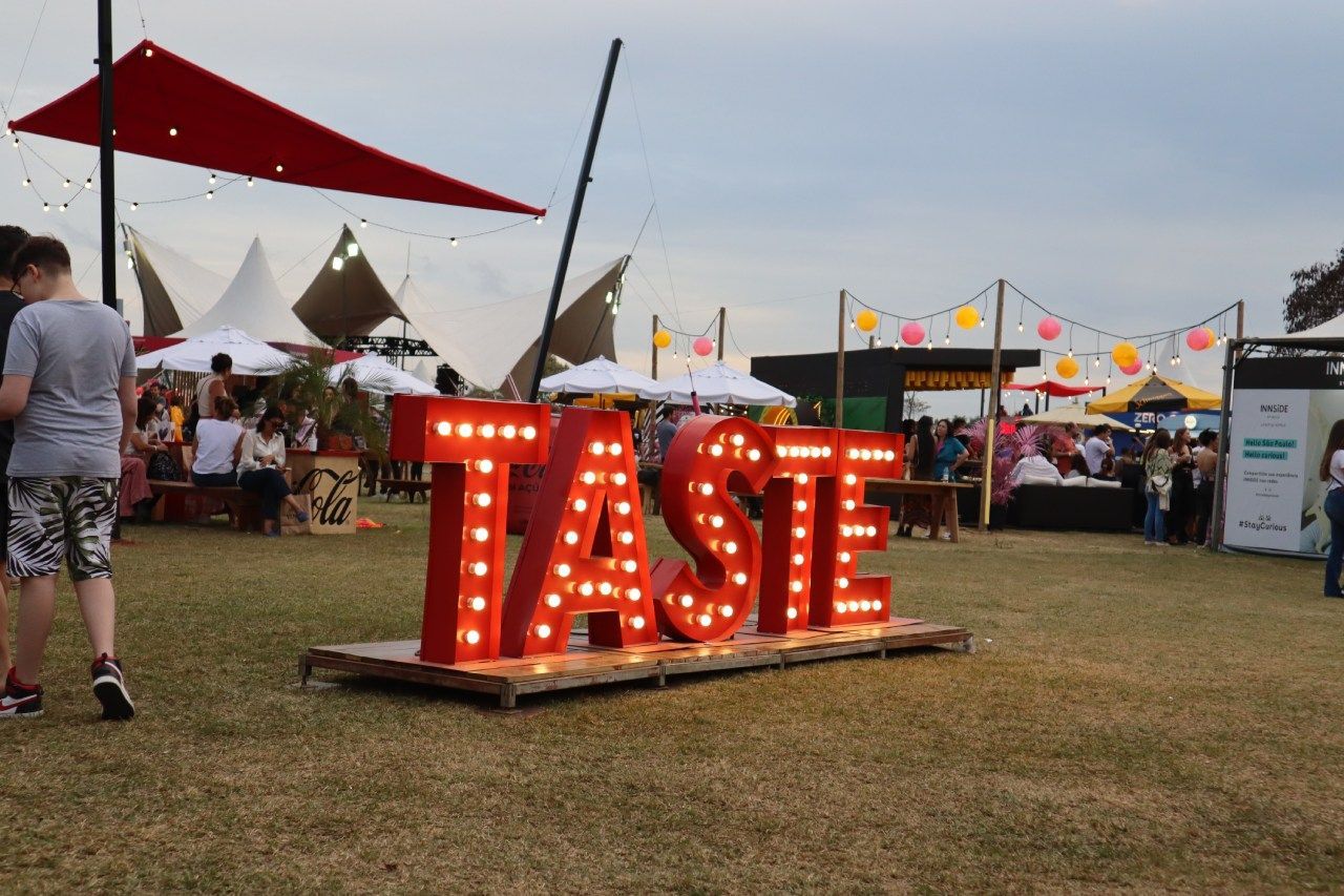 Uma grande placa vermelha que diz que o sabor está iluminado em um campo