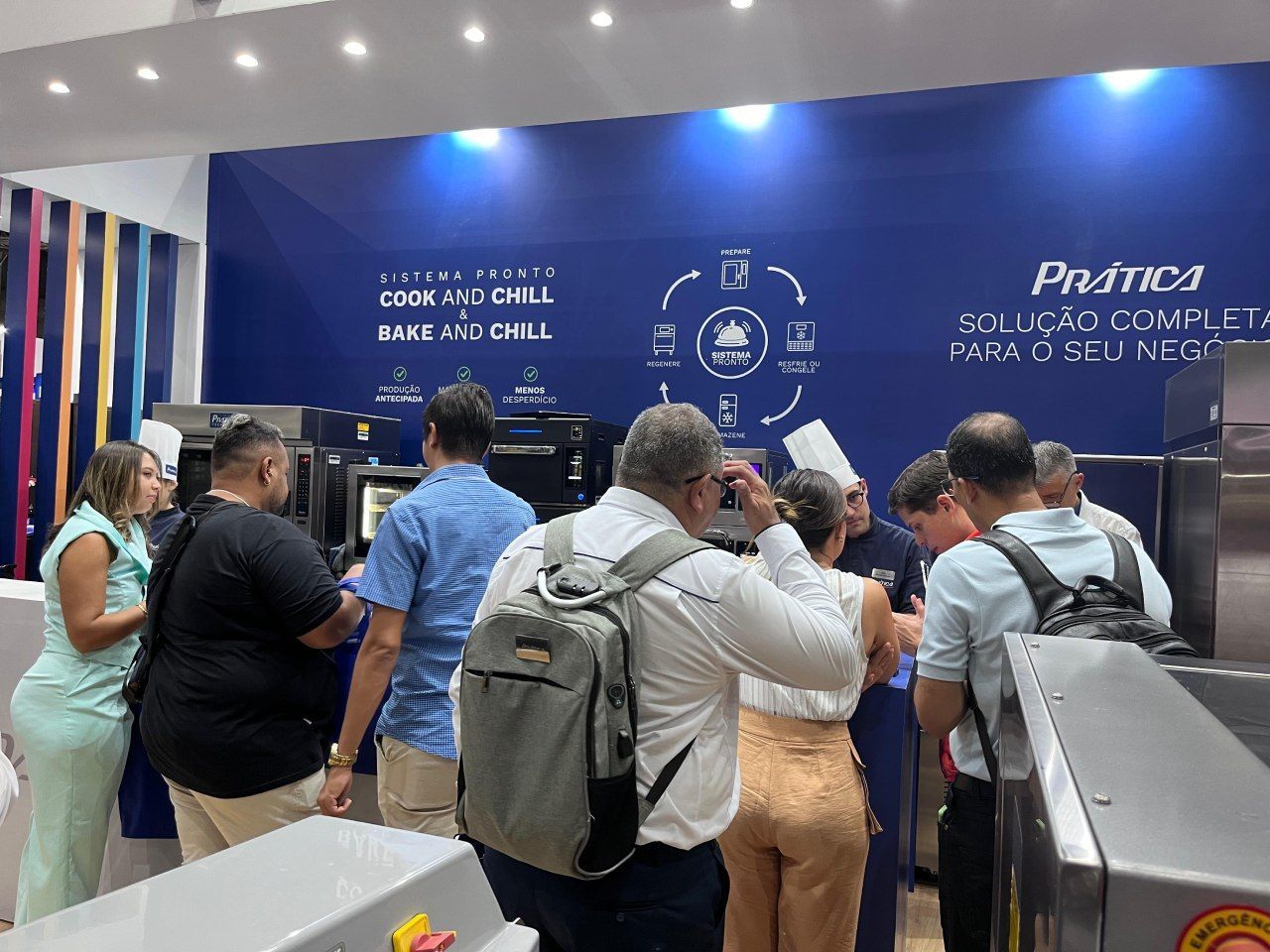 Um grupo de pessoas está em uma sala olhando para uma máquina.