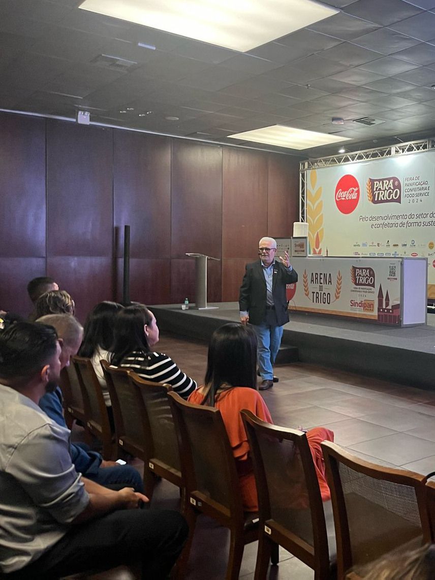 Um homem está fazendo uma apresentação para um grupo de pessoas em uma sala.