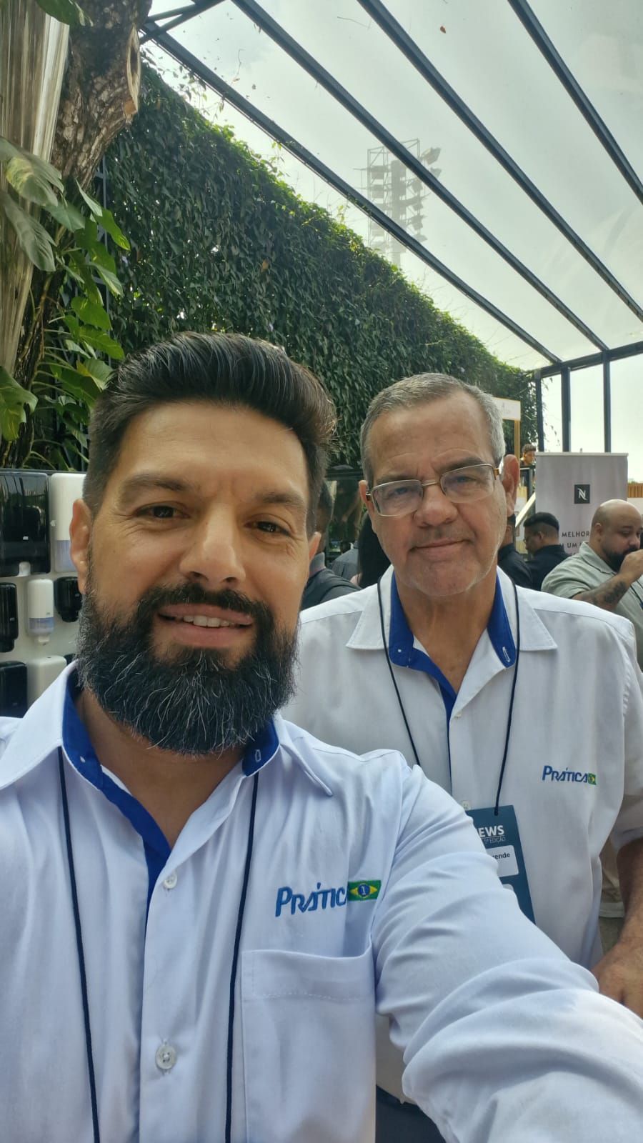 Um homem com barba está tirando uma selfie com outro homem.