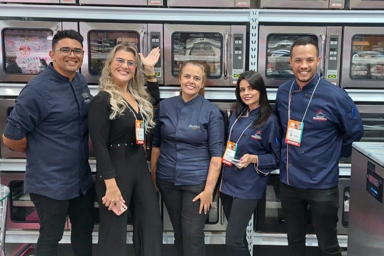 Um grupo de pessoas está posando para uma foto em frente a uma lavanderia.