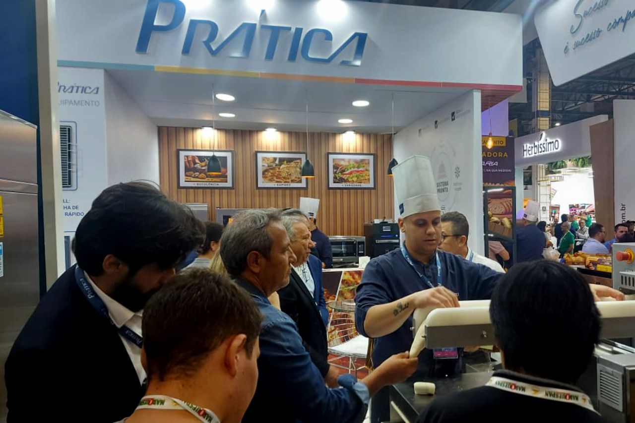 Um grupo de pessoas está parado sob uma placa que diz pratica