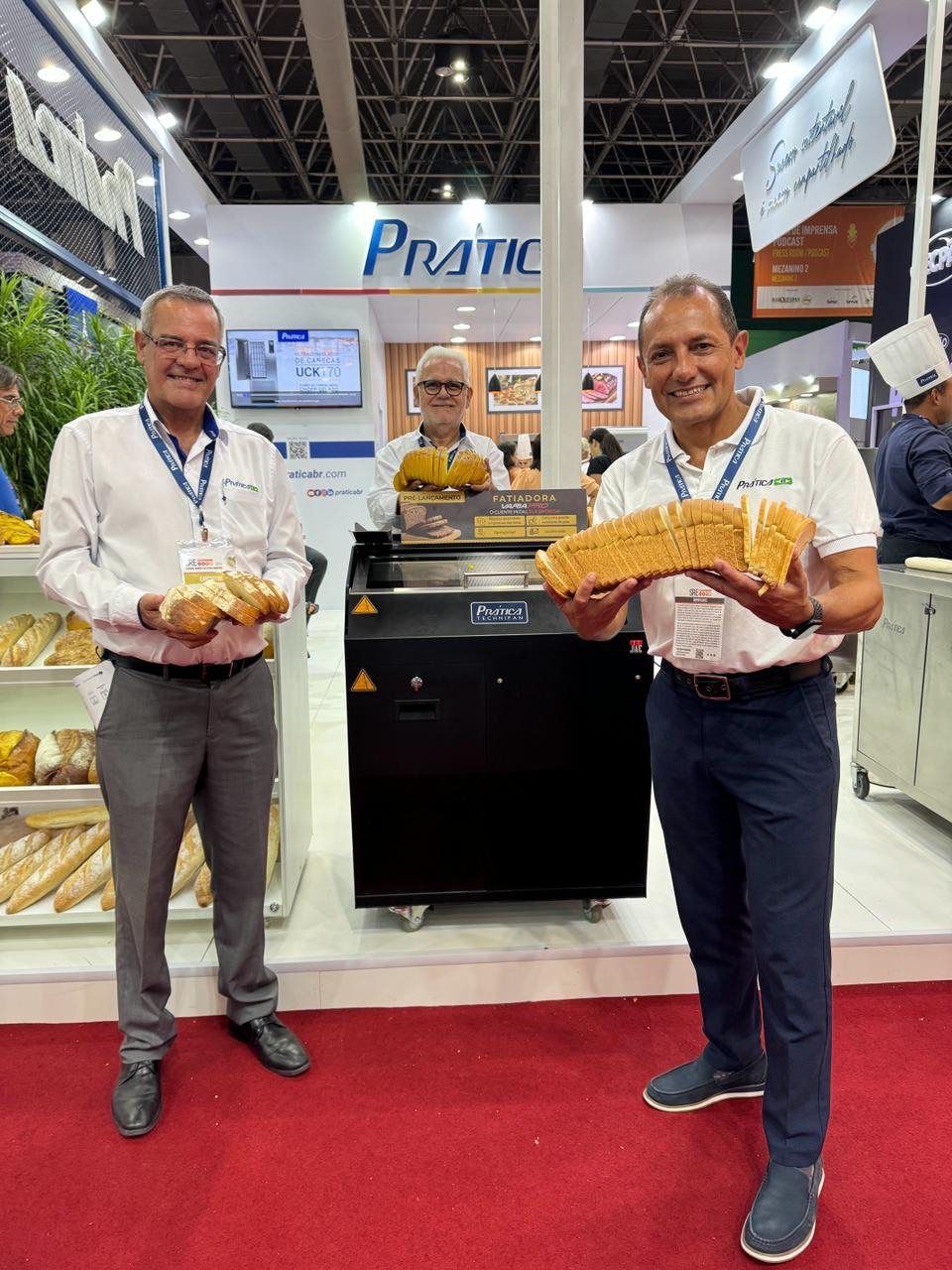 Dois homens estão um ao lado do outro segurando pão.