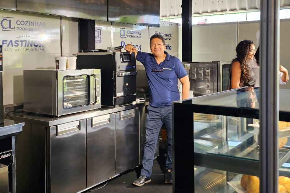 Um homem de camisa azul está parado na cozinha.