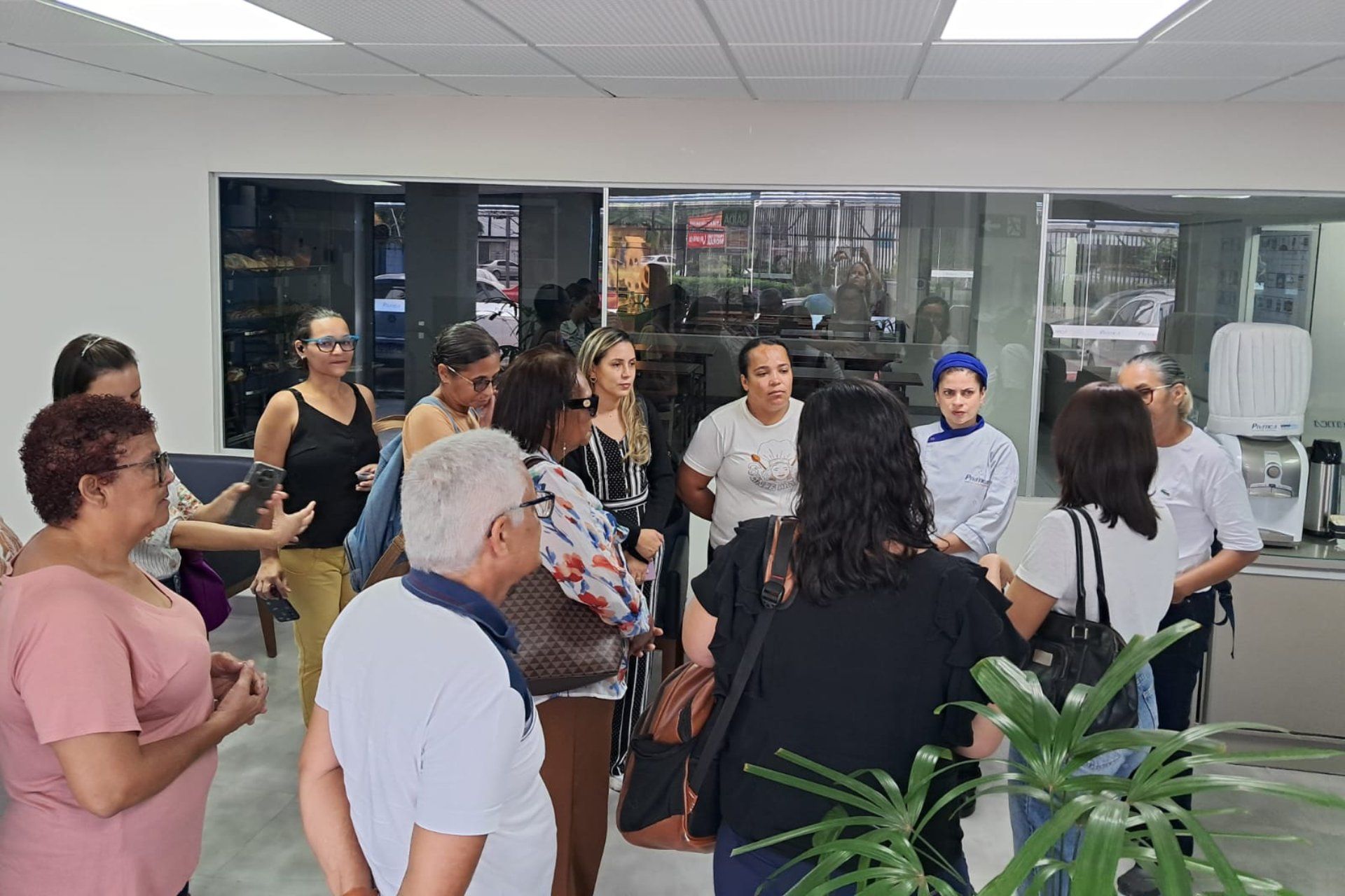 Um grupo de pessoas está em uma sala conversando entre si.