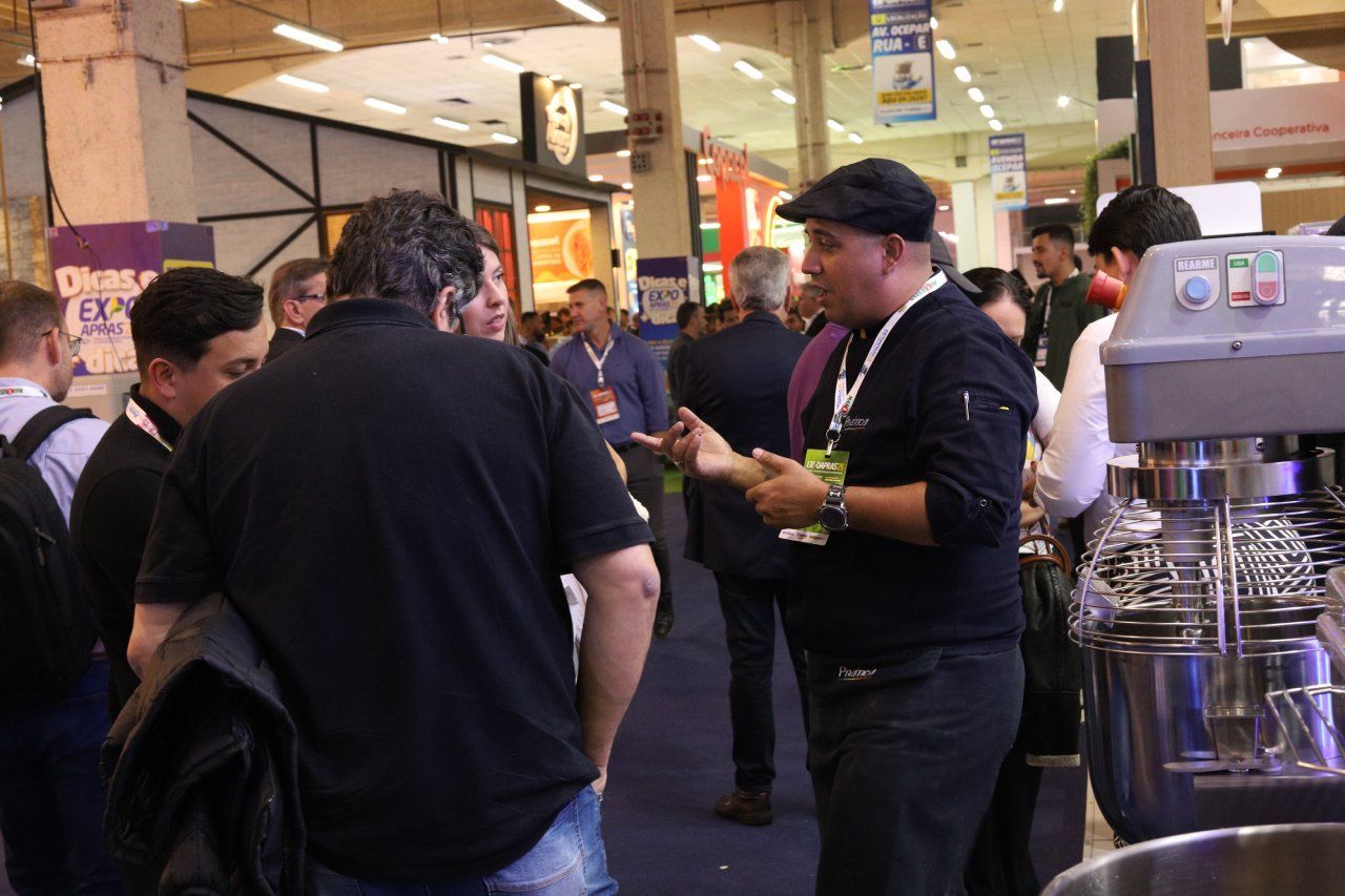 Um grupo de pessoas está em volta de uma máquina em uma sala.