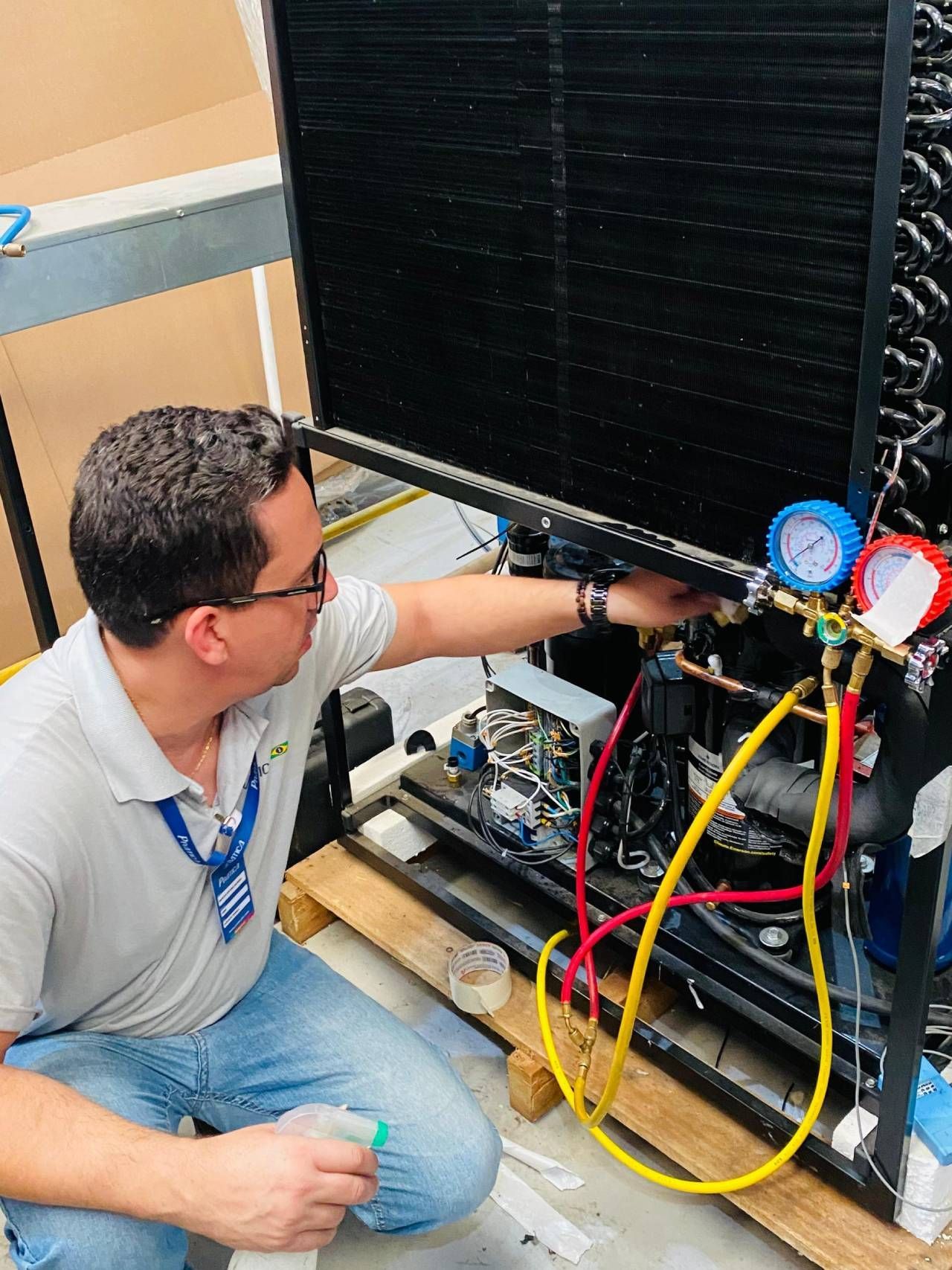 Um homem está trabalhando em uma geladeira em uma fábrica.