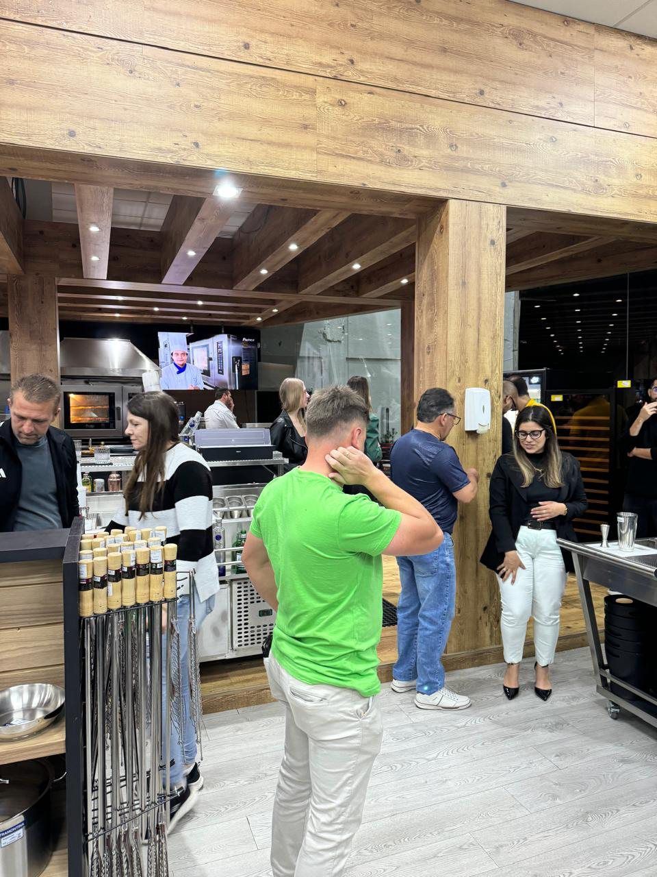 Um homem de camisa verde está em um restaurante com outras pessoas.