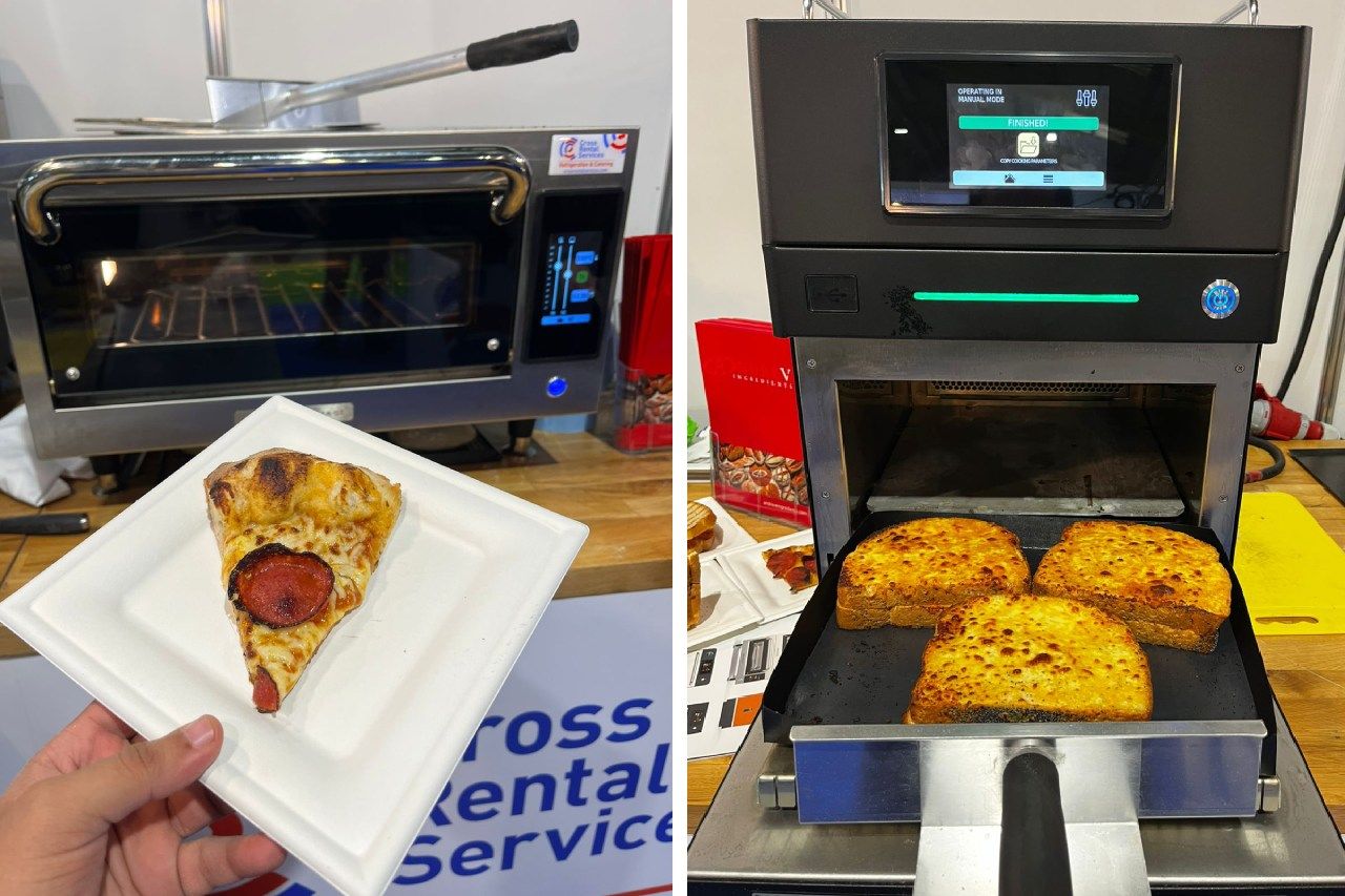 Uma pessoa está segurando um prato de pizza ao lado de uma máquina que faz pizza.