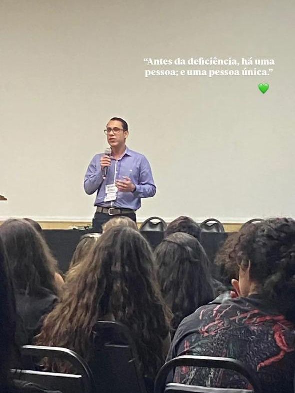 Um homem está fazendo uma apresentação para um grupo de pessoas sentadas em cadeiras.