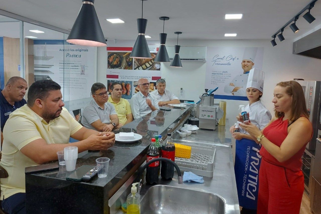 Um grupo de pessoas está sentado em um balcão na cozinha.