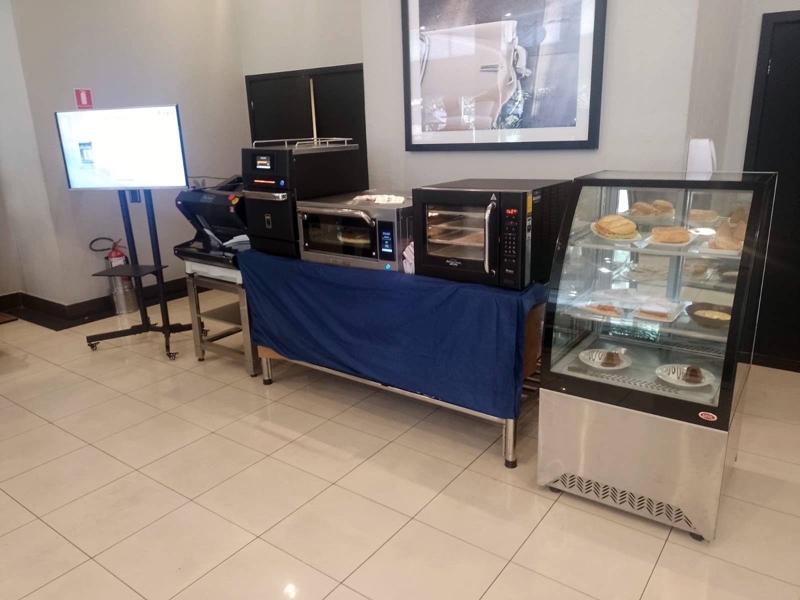 Uma sala com uma mesa e uma vitrine cheia de comida.
