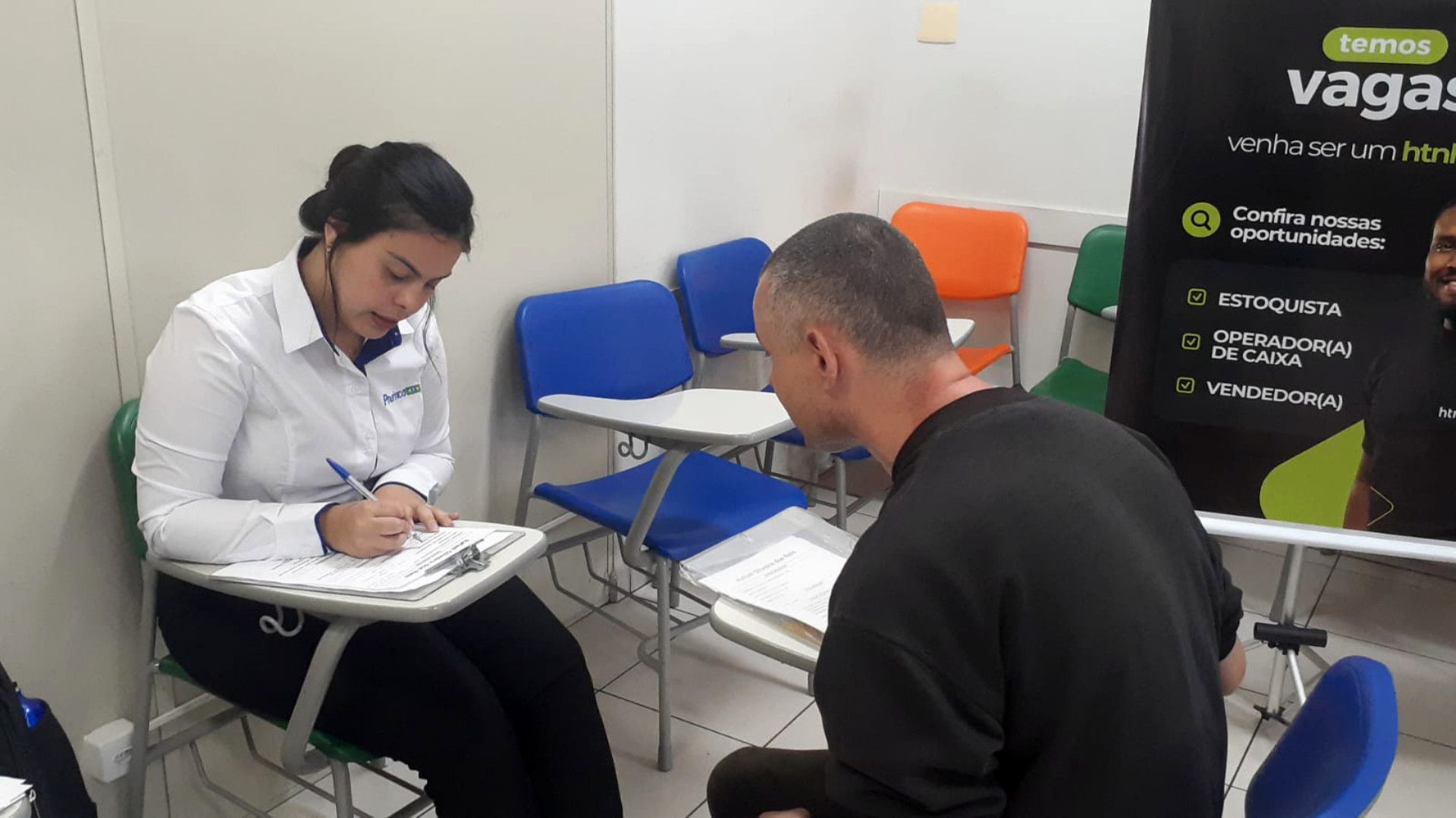 Uma mulher está sentada em uma mesa conversando com um homem.