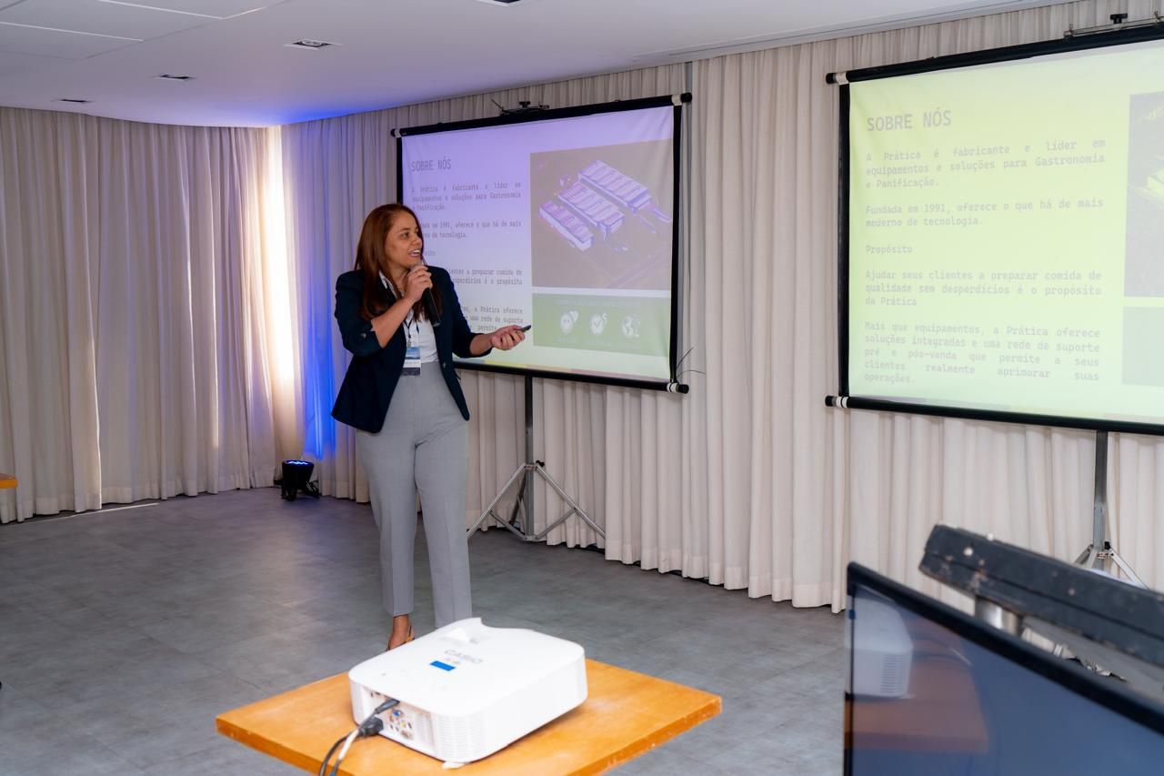 Uma mulher está fazendo uma apresentação em frente a uma tela de projetor.