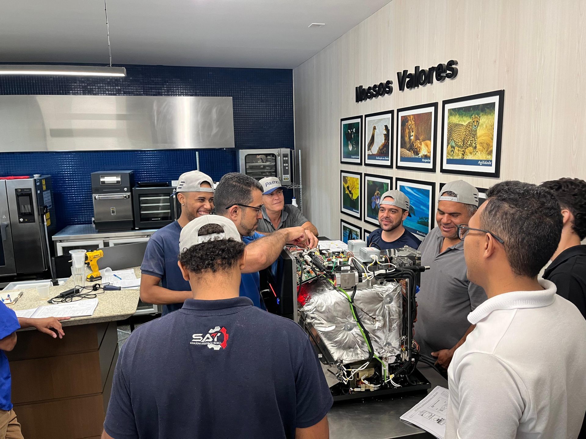 Um grupo de homens está em volta de uma máquina em uma cozinha.