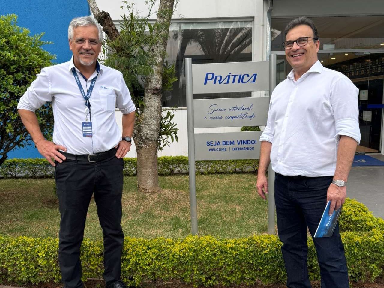 Dois homens estão parados em frente a uma placa que diz pharma