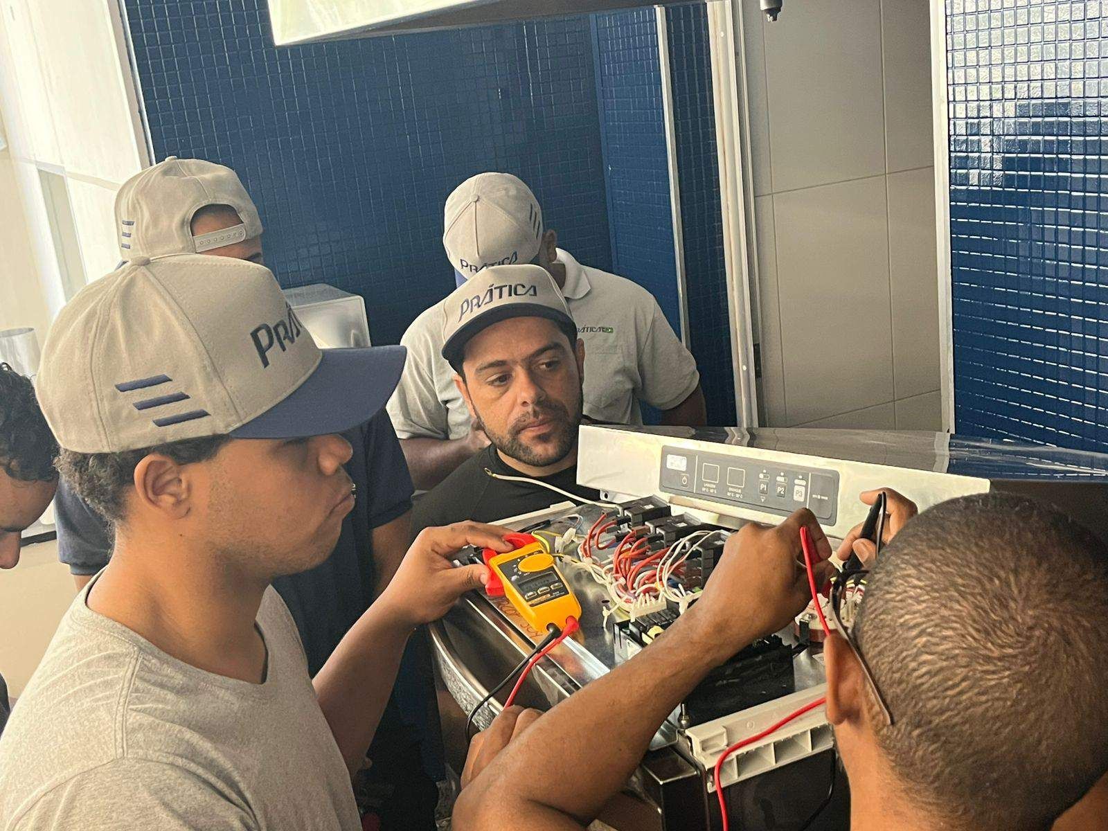 Um grupo de homens está trabalhando em uma máquina em frente a um espelho.