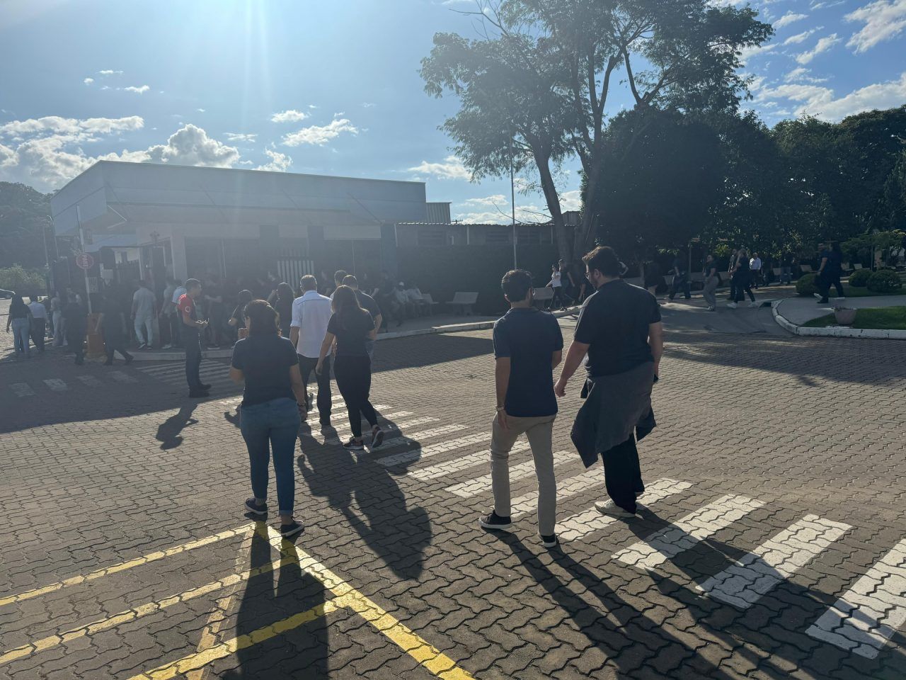 Um grupo de pessoas está caminhando por uma calçada de tijolos.