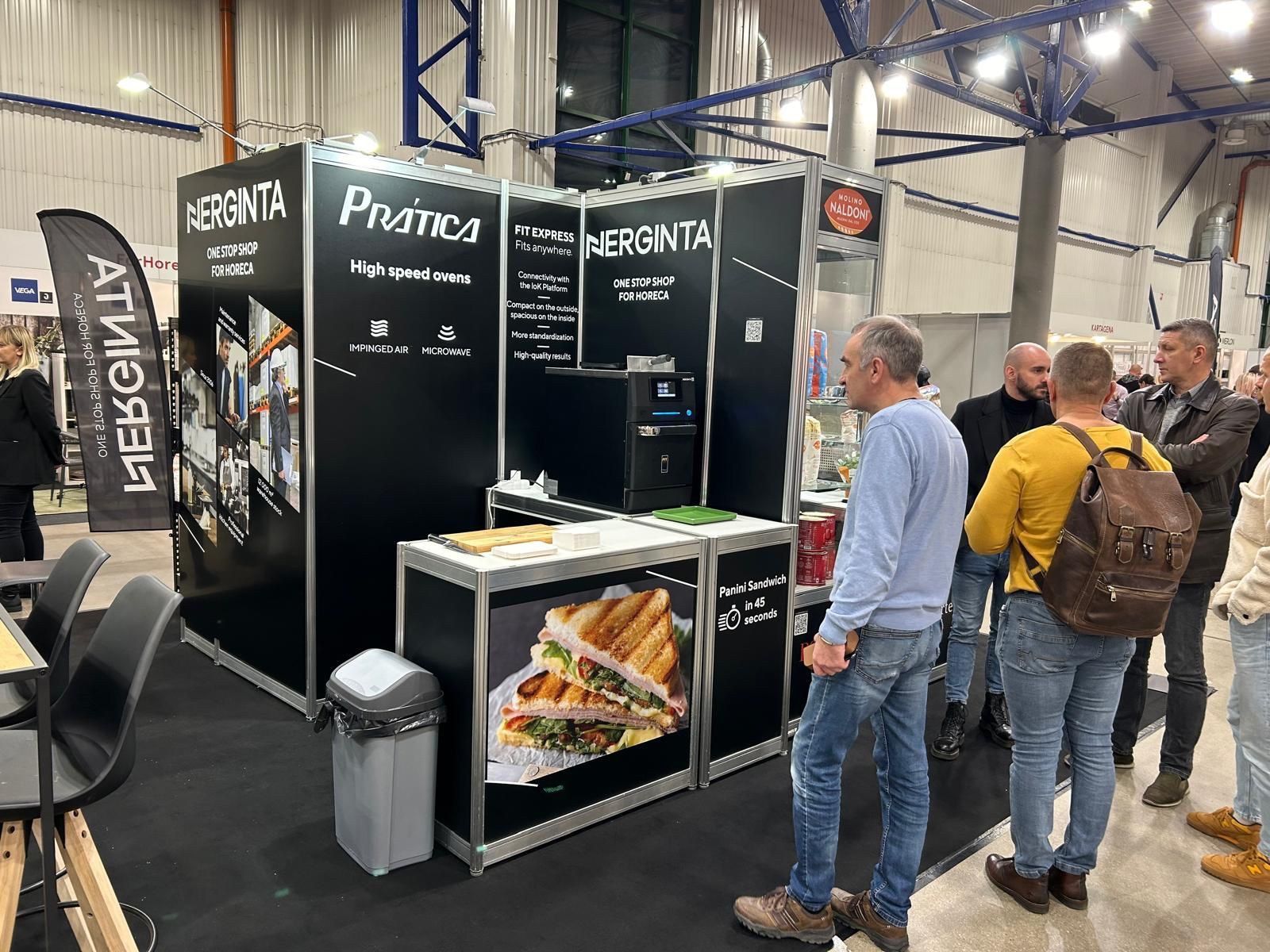 Um grupo de pessoas está em volta de um estande em uma convenção.