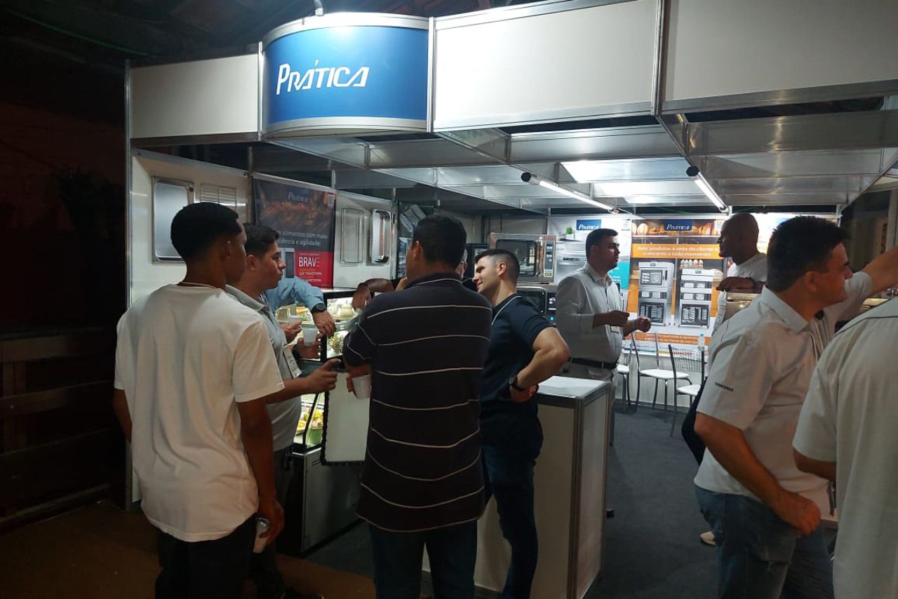 Um grupo de pessoas está em frente a uma placa que diz pratica