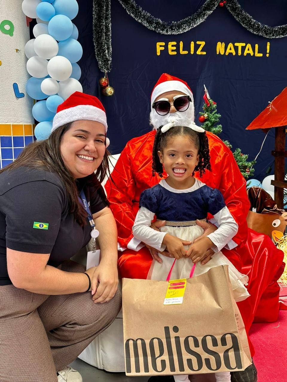 Uma menina está posando para uma foto com o papai noel