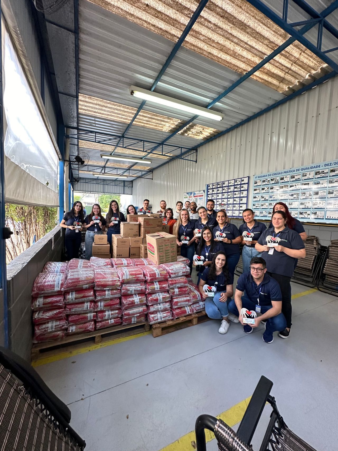 Um grupo de pessoas está posando para uma foto em um armazém.