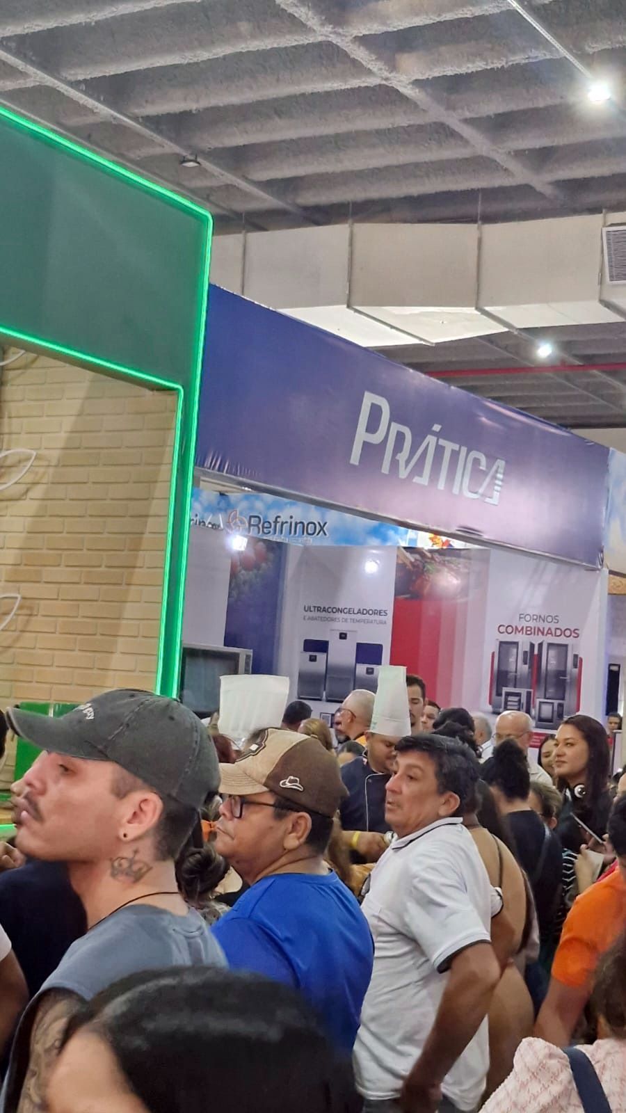 Multidão em uma exposição, faixa azul com o texto 