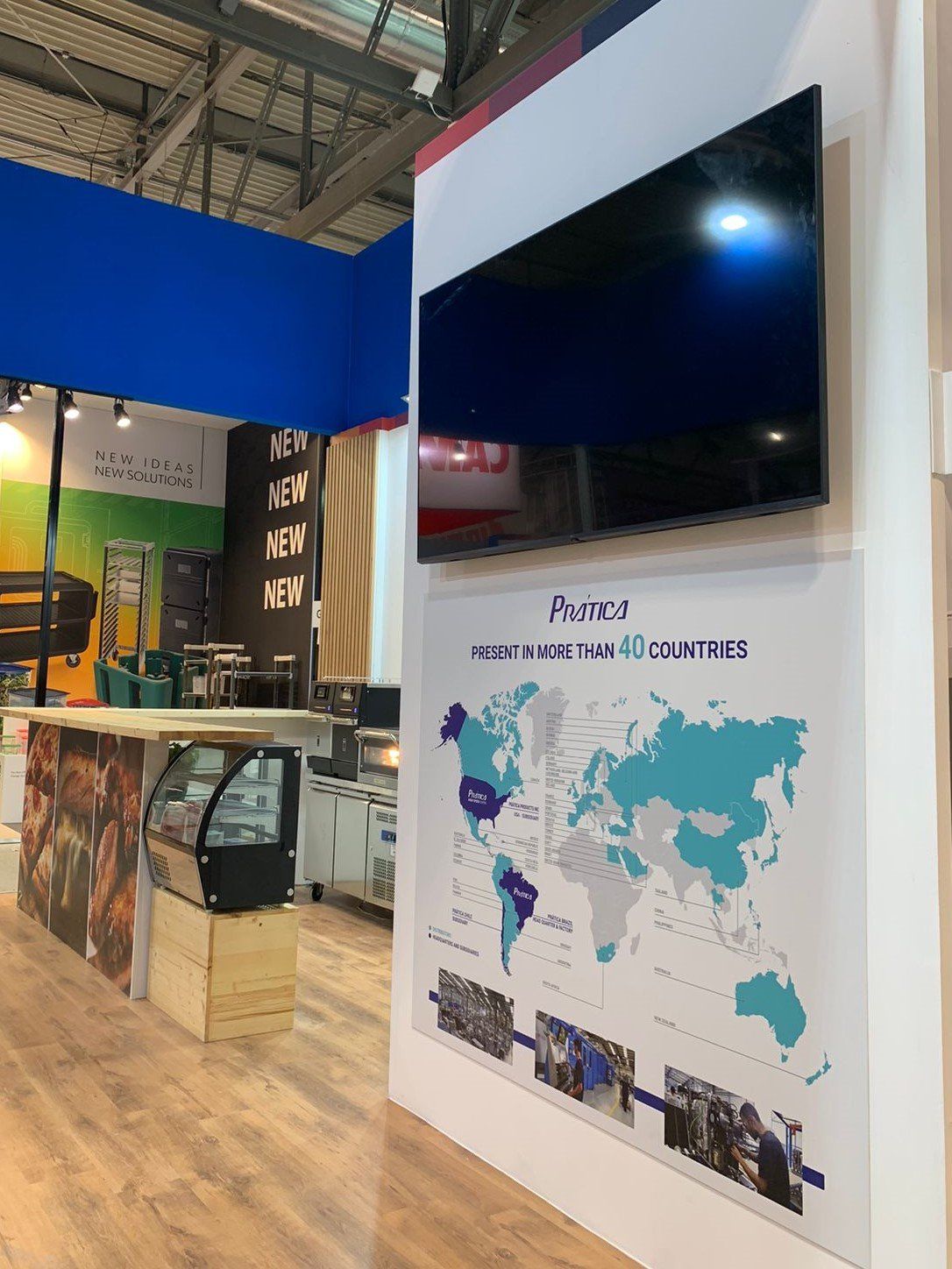 Uma grande TV de tela plana está pendurada na parede ao lado de um mapa-múndi.