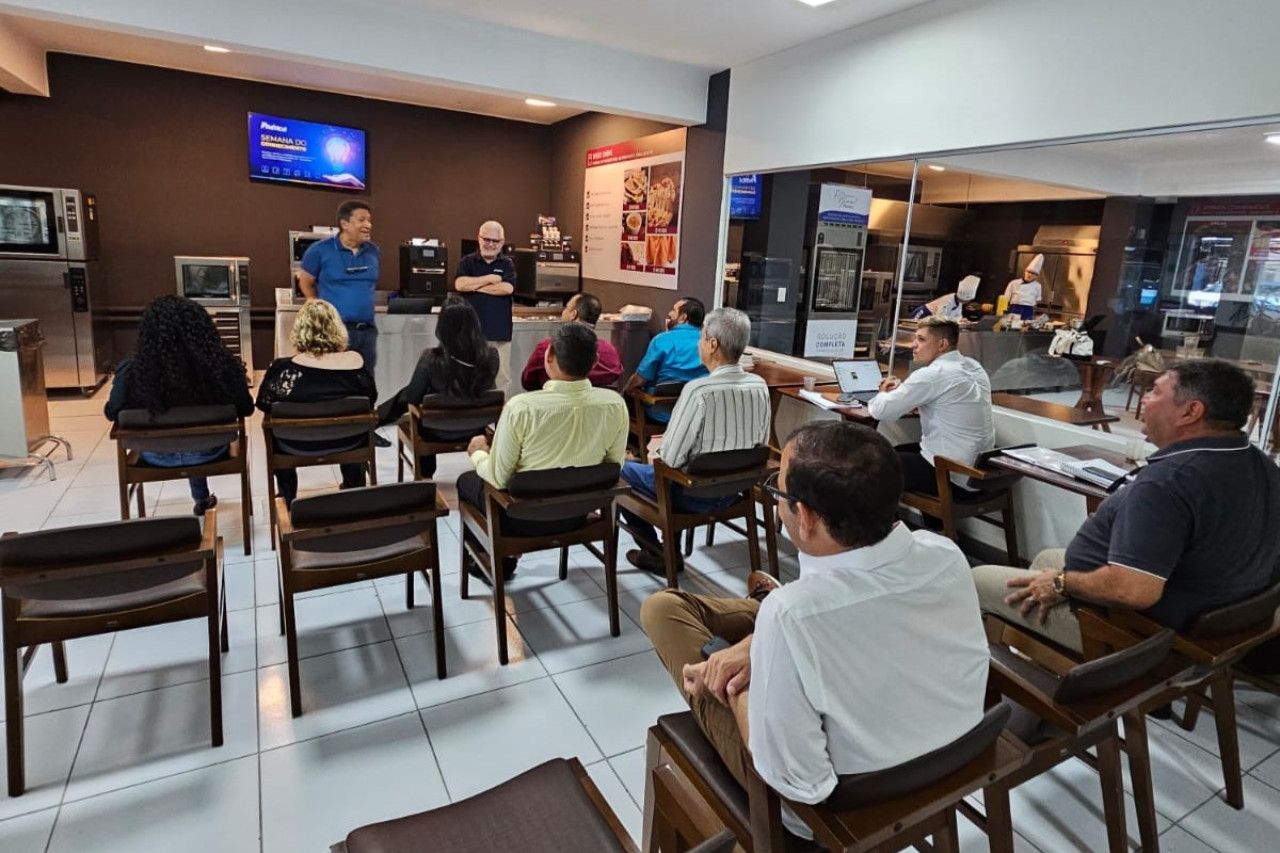 Um grupo de pessoas está sentado em cadeiras em uma sala.