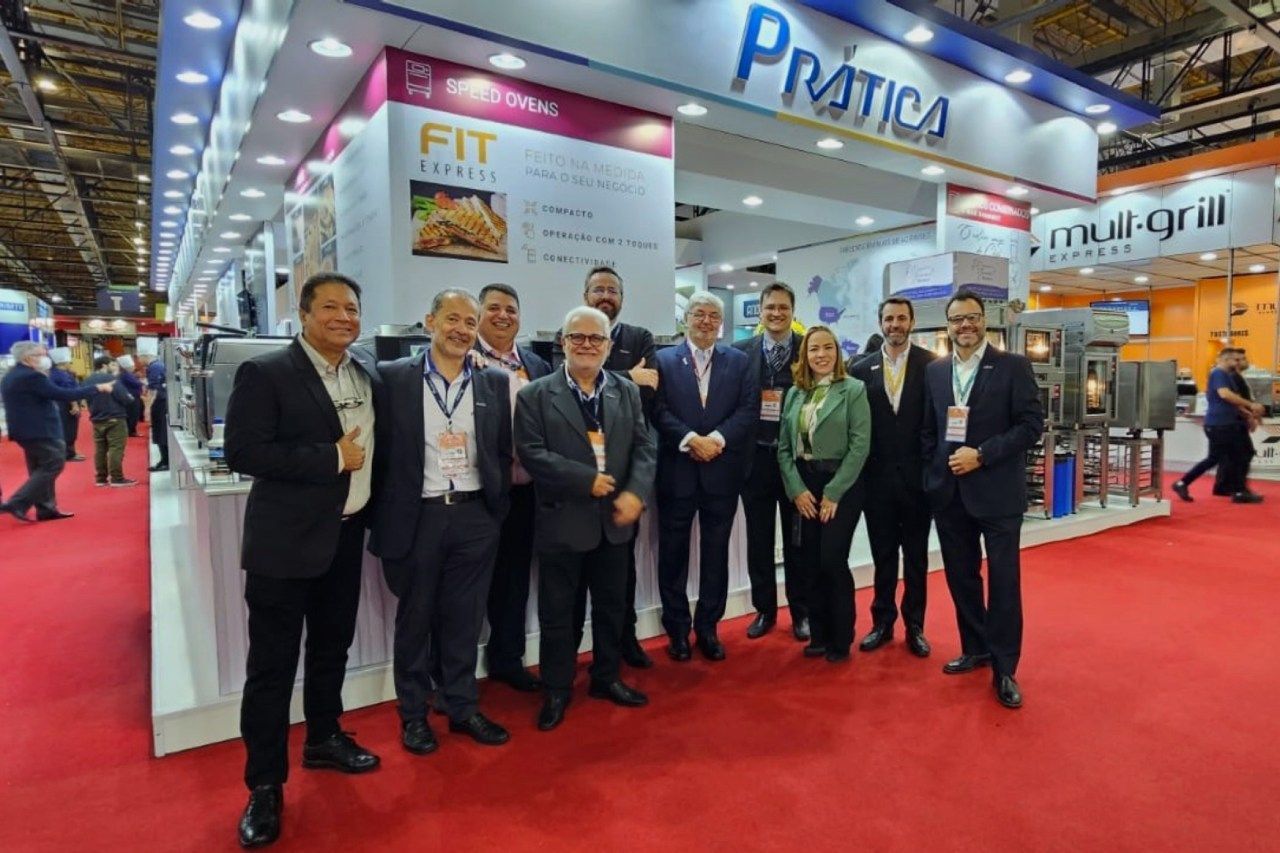 Um grupo de pessoas está em frente a um estande em uma convenção.