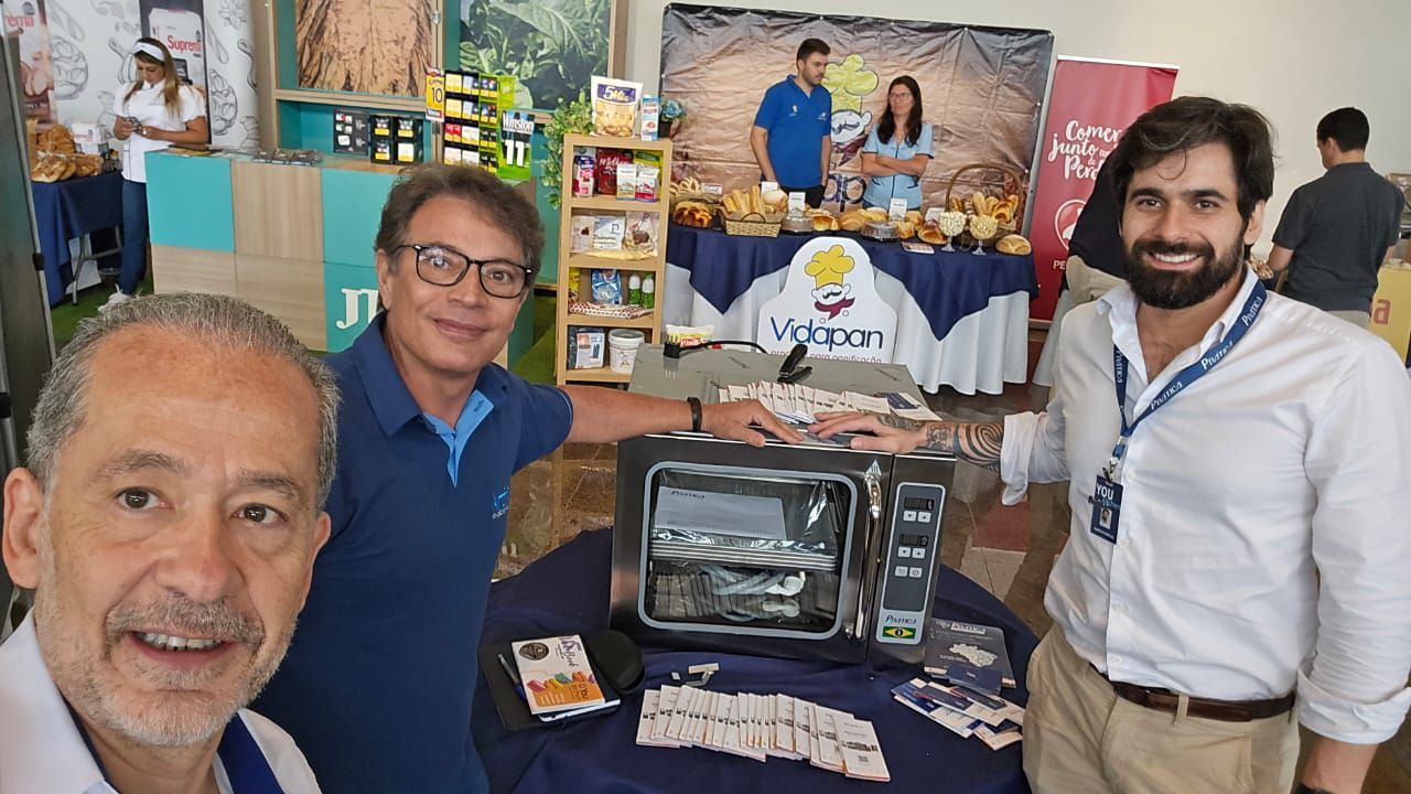 Um grupo de homens está posando para uma foto em frente a uma mesa.