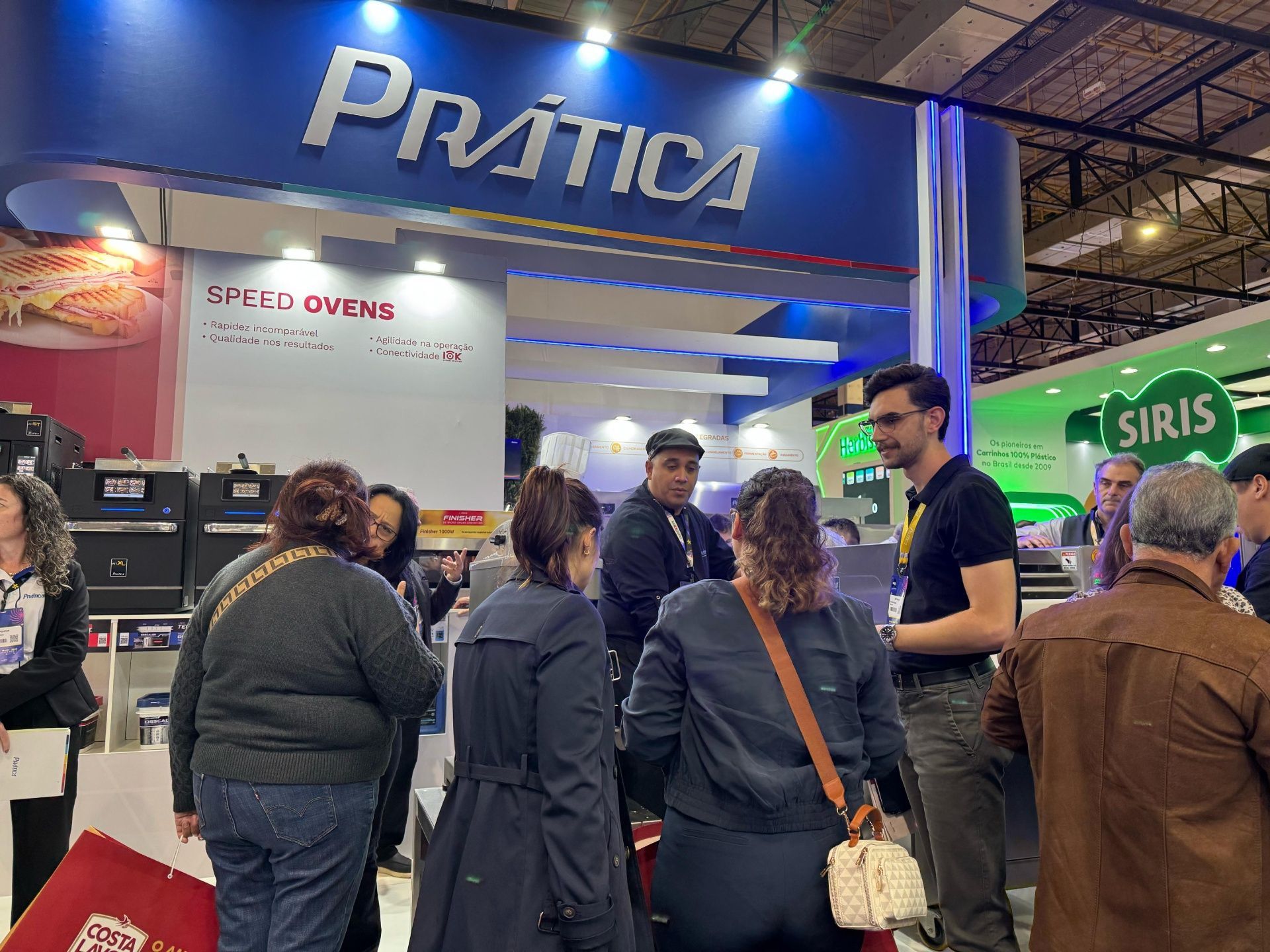 Um grupo de pessoas está em frente a uma placa de prática.