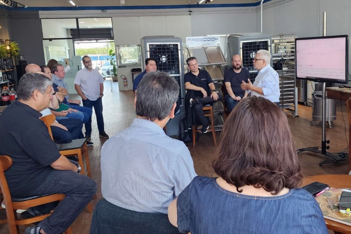 Um grupo de pessoas está sentado em círculo em uma sala.