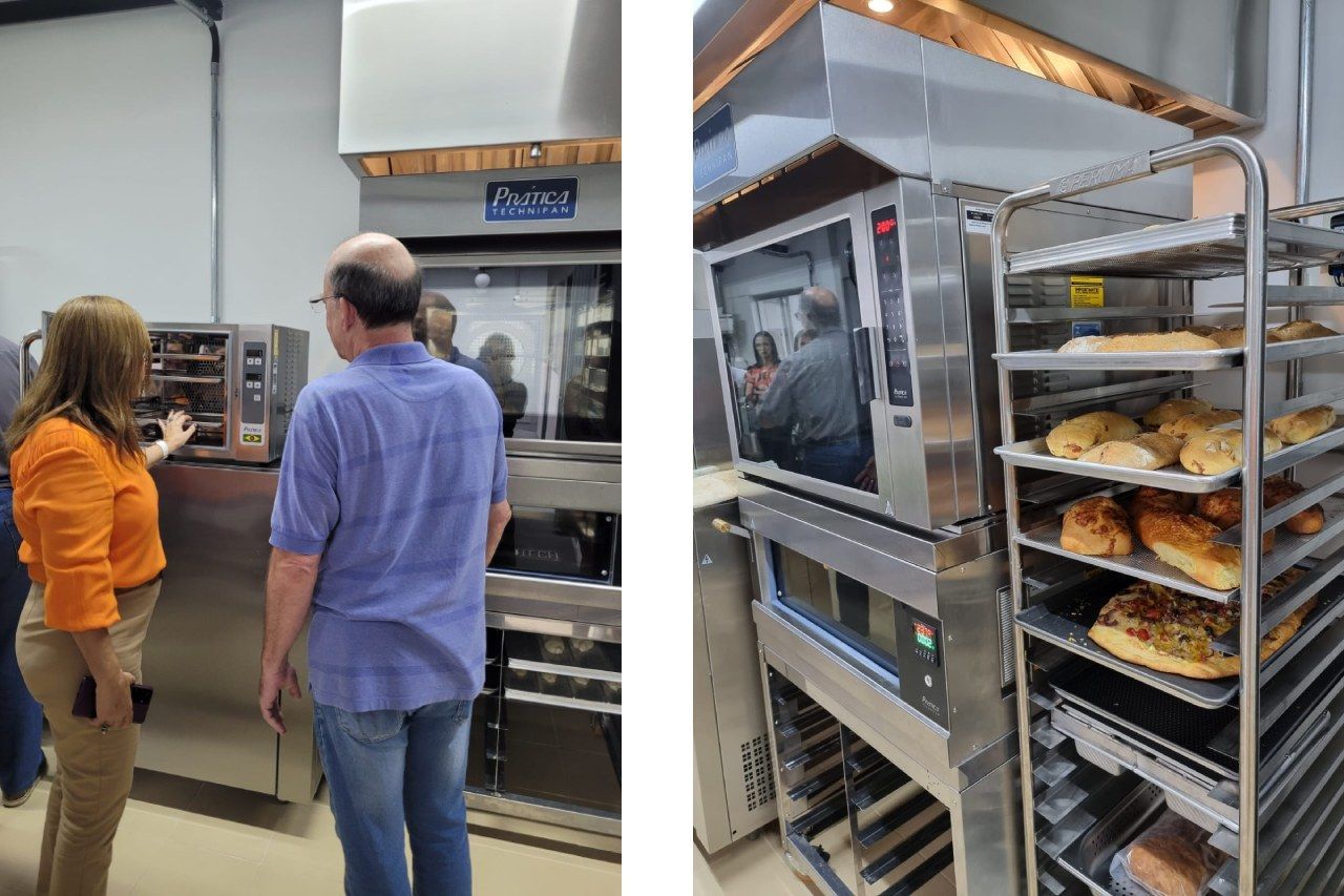 Um homem e uma mulher estão em frente a um forno de padaria.