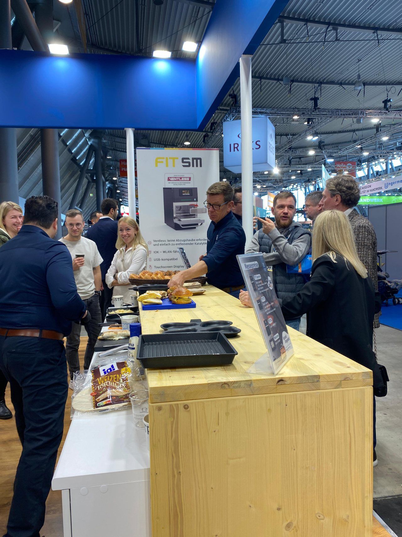 Um grupo de pessoas está em volta de uma mesa em uma convenção.