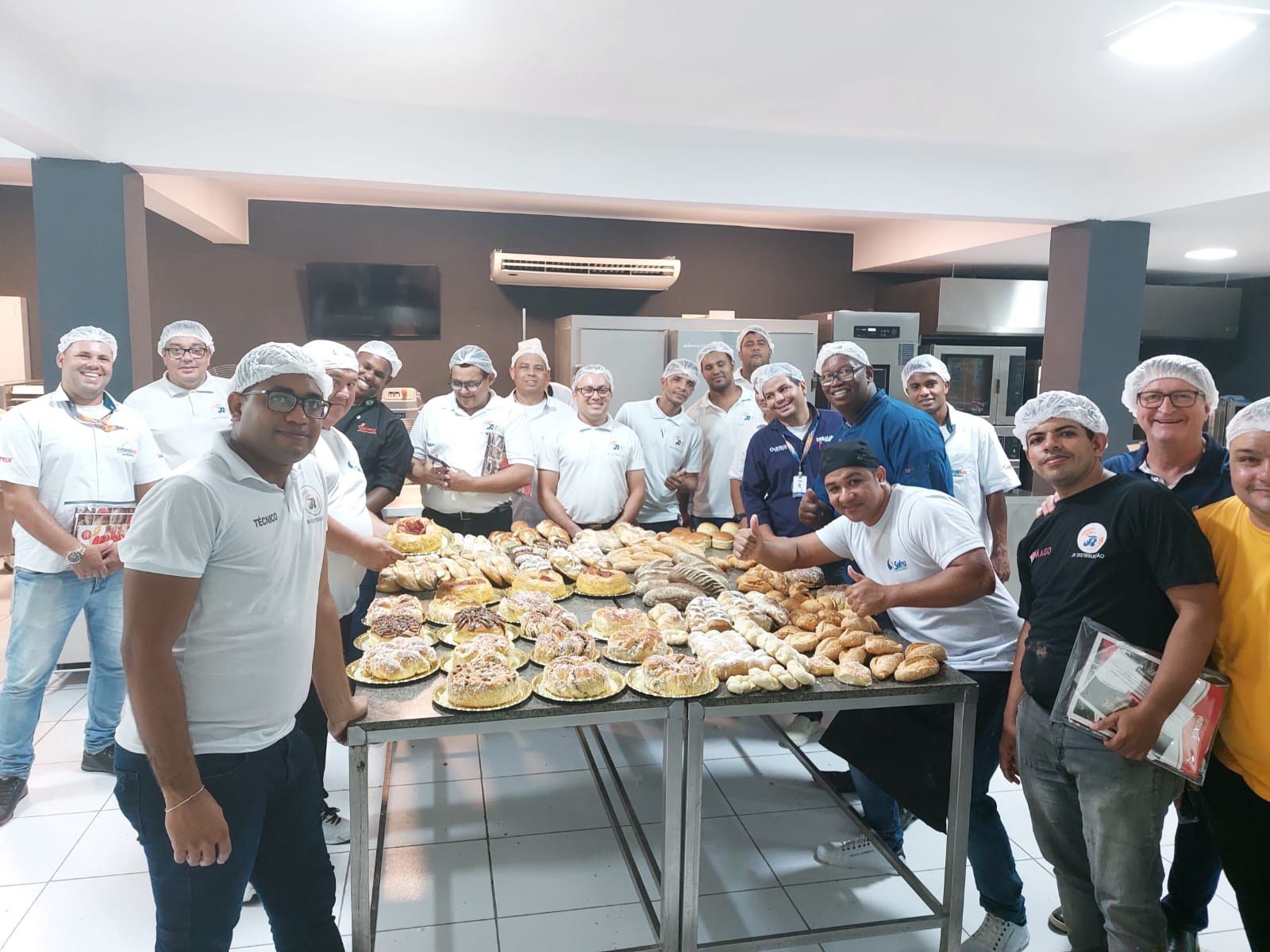 Um grupo de homens está em pé em frente a uma mesa cheia de comida.