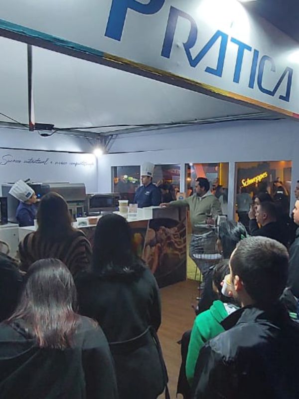 Um grupo de pessoas sentadas sob uma placa que diz 'pratica'