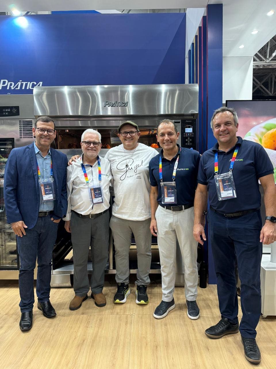 Um grupo de homens está posando para uma foto em frente a um forno.