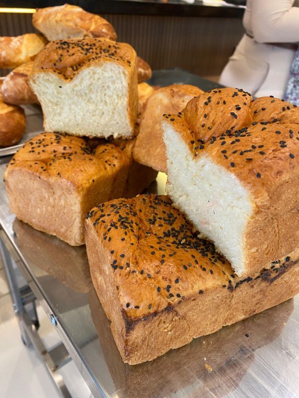 Um pão com sementes de gergelim está sobre uma mesa.