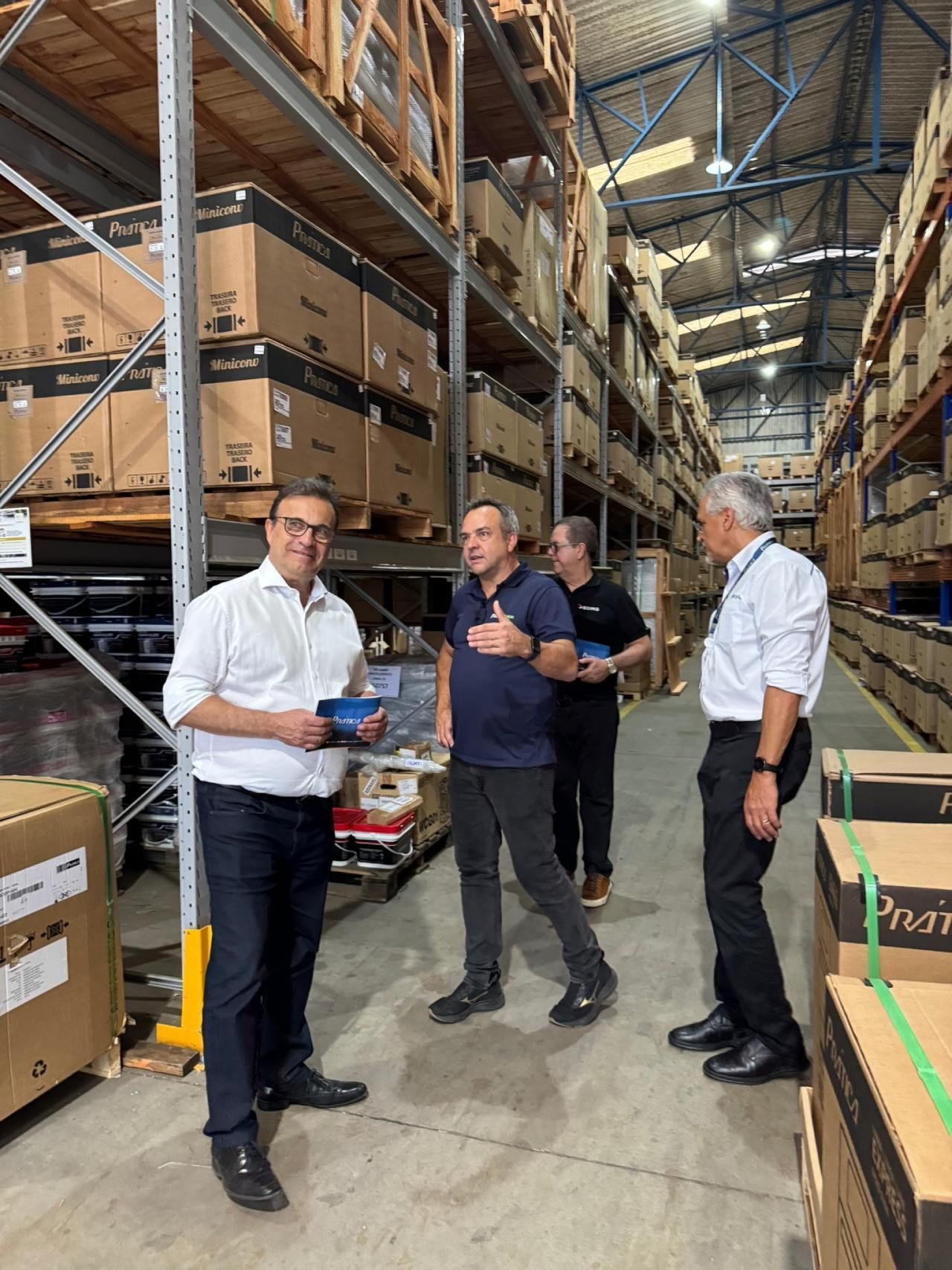 Um grupo de homens está em um armazém conversando entre si.