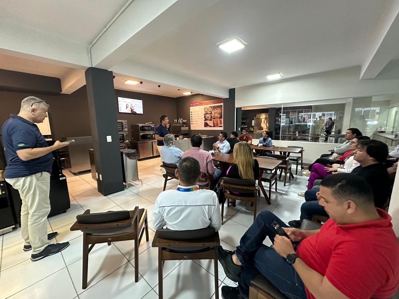 Um grupo de pessoas está sentado em cadeiras em uma sala.