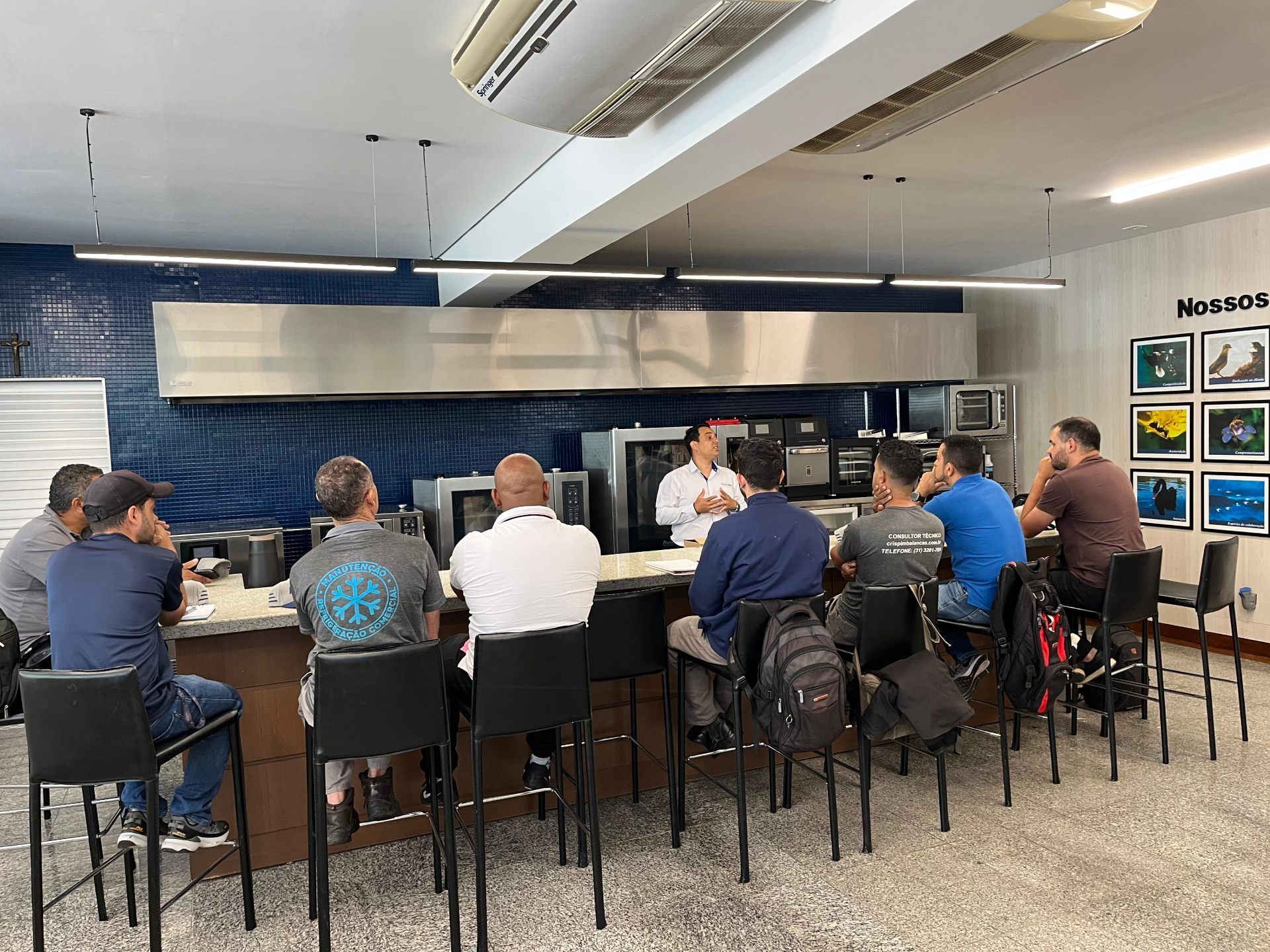 Um grupo de homens está sentado à mesa na cozinha.