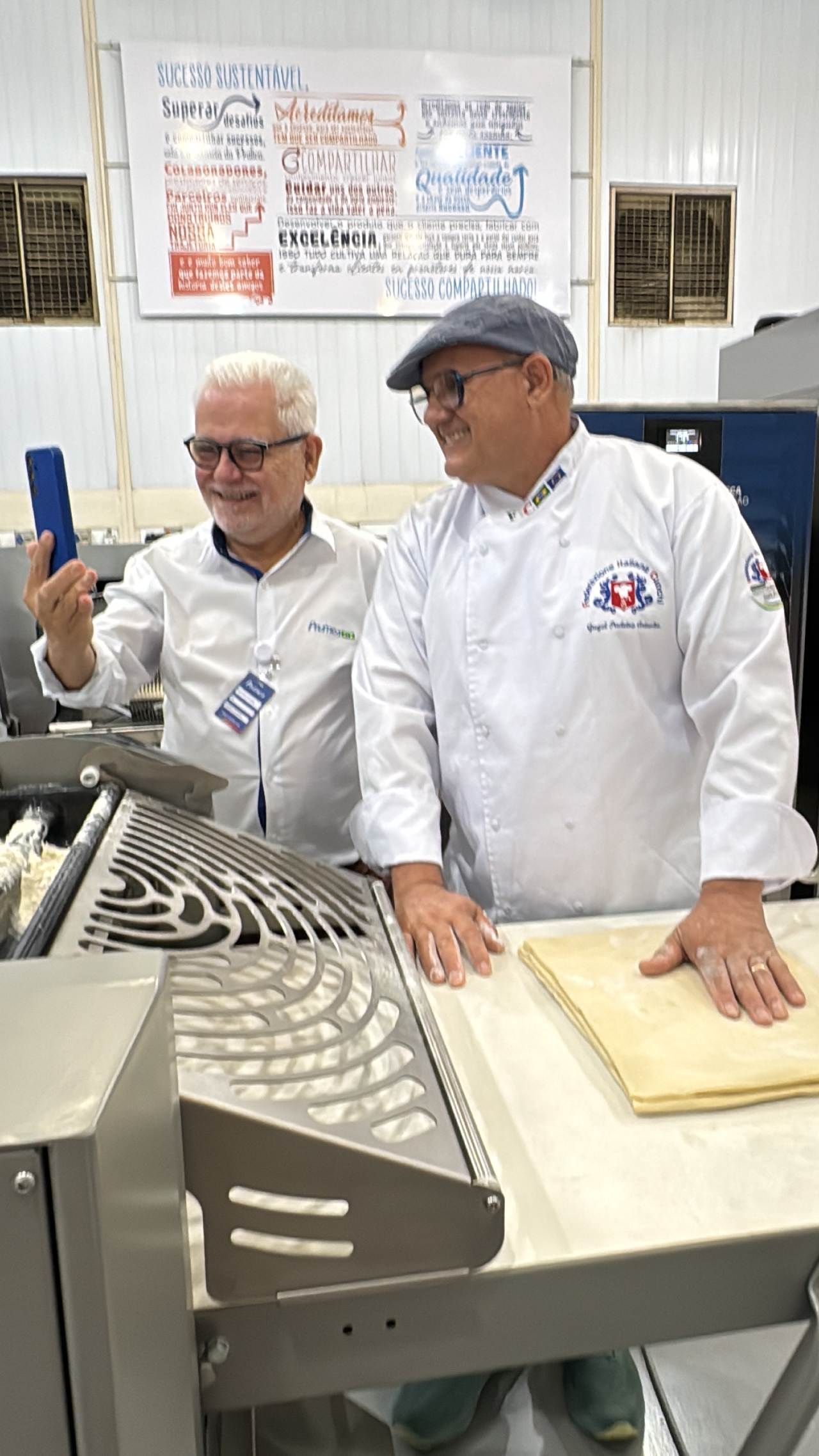 Dois homens estão parados um ao lado do outro em uma cozinha.